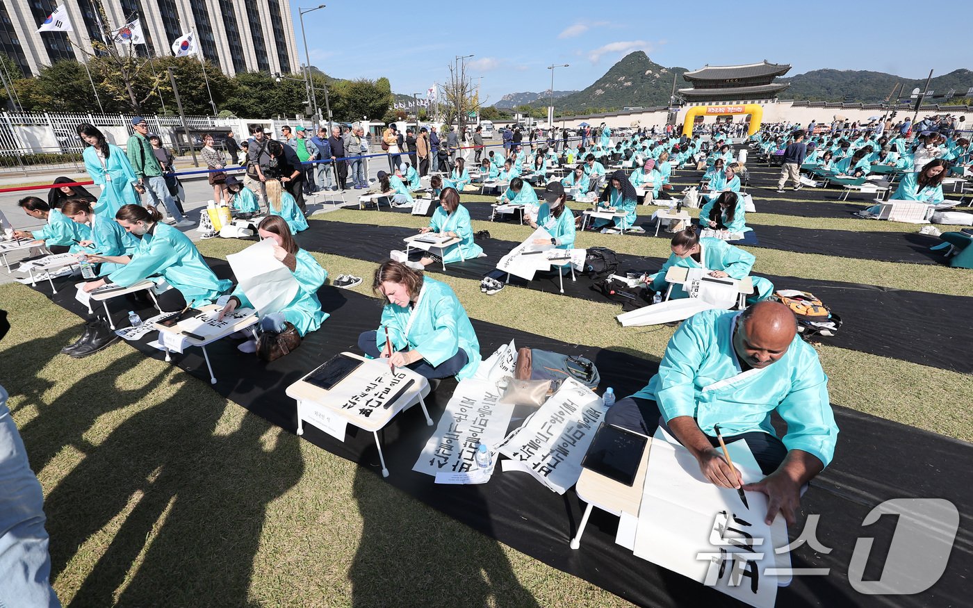 본문 이미지 - 제578돌 한글날을 맞은 9일 오전 서울 종로구 광화문광장에서 한국예술문화원 주체로 열린 조선시대 과거 시험 재현 '휘호대회'에서 외국인 참가자들이 글씨를 적고 있다. 2024.10.9/뉴스1 ⓒ News1 김성진 기자