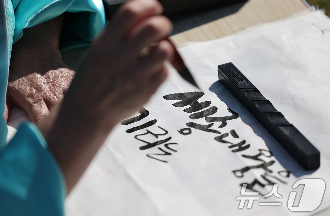 본문 이미지 - 제578돌 한글날을 맞은 9일 오전 서울 종로구 광화문광장에서 한국예술문화원 주체로 열린 조선시대 과거 시험 재현 '휘호대회'에서 한 참가자가 글씨를 쓰고 있다. 2024.10.9/뉴스1 ⓒ News1 김성진 기자