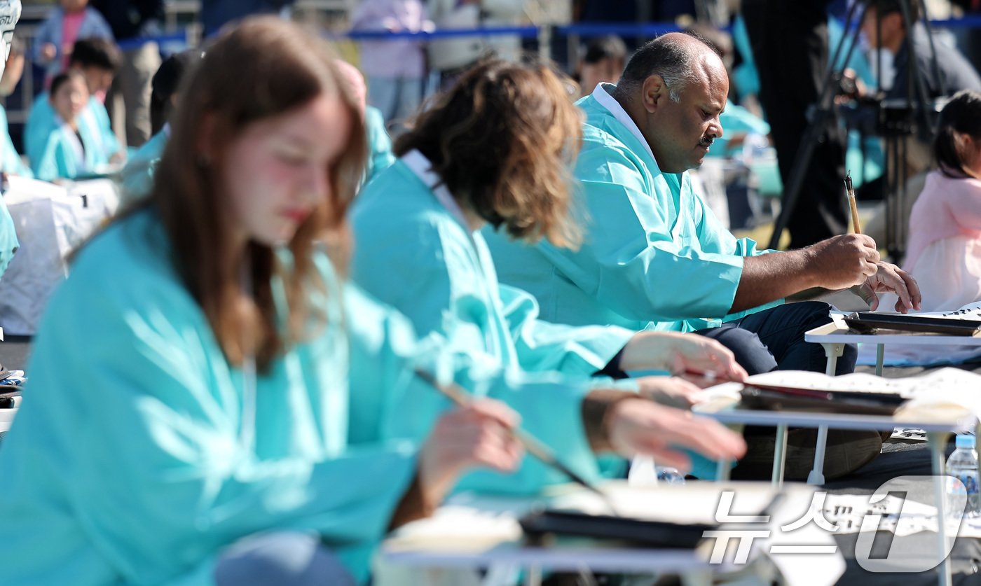 본문 이미지 - 제578돌 한글날을 맞은 9일 오전 서울 종로구 광화문광장에서 한국예술문화원 주체로 열린 조선시대 과거 시험 재현 '휘호대회'에서 외국인 참가자들이 글씨를 쓰고 있다. 2024.10.9/뉴스1 ⓒ News1 김성진 기자