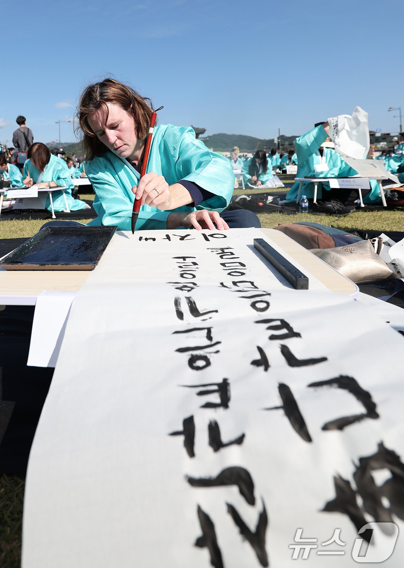 본문 이미지 - 제578돌 한글날을 맞은 9일 오전 서울 종로구 광화문광장에서 한국예술문화원 주체로 열린 조선시대 과거 시험 재현 '휘호대회'에서 외국인 참가자들이 글씨를 적고 있다. 2024.10.9/뉴스1 ⓒ News1 김성진 기자