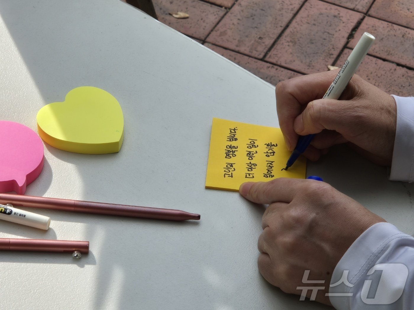 본문 이미지 - 19명의 사상자를 낸 부천 호텔 화재 유가족들이 9일 부천시청 앞에 마련된 합동분향소에서 시민 추모제를 개최했다. 한 시민이 포스트잇에 추모사를 적고 있다. 2024.10.9/뉴스1 ⓒ News1 이시명 기자