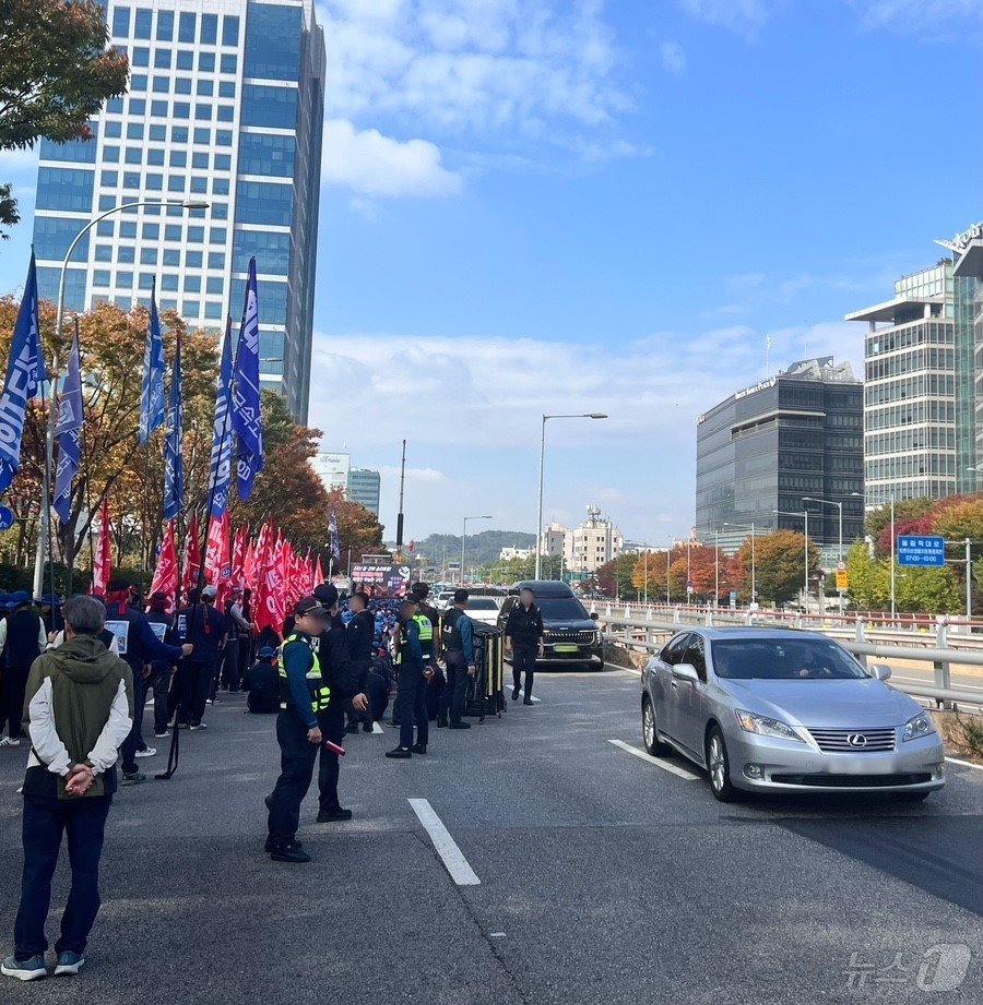 본문 이미지 -  현대트랜시스 노조가 한 달 가까이 파업 중이다. 사진은 지난달 28일 노조원 등 1000여명이 현대차·기아 서울 양재사옥 앞 3개 차선을 막고 집회 중인 가운데 차량들이 남은 1개 차선으로 시위대 옆을 아슬아슬하게 지나가는 모습.(독자 제공)