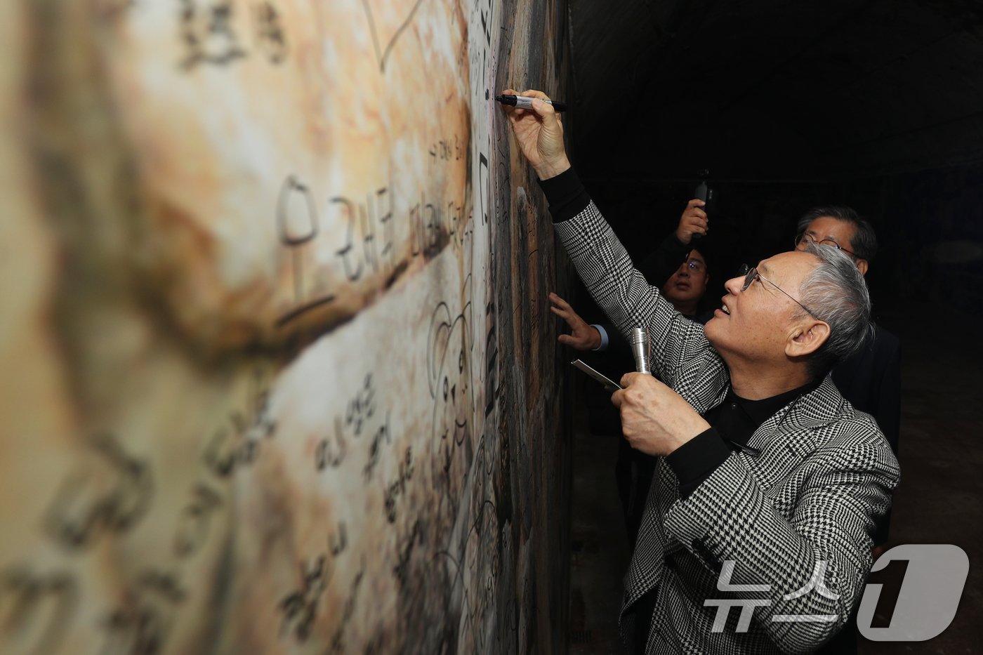 본문 이미지 - 유인촌 문화체육관광부 장관이 1일 충북 청주시 당산 생각의 벙커 벽면에 메시지를 적고 있다. 당산 벙커는 과거 전시 지휘 통제소와 충무시설로 활용했던 곳으로, 최근 문화공간으로 꾸며 일반인에게 공개했다. 2024.11.1/뉴스1 ⓒ News1 김용빈 기자