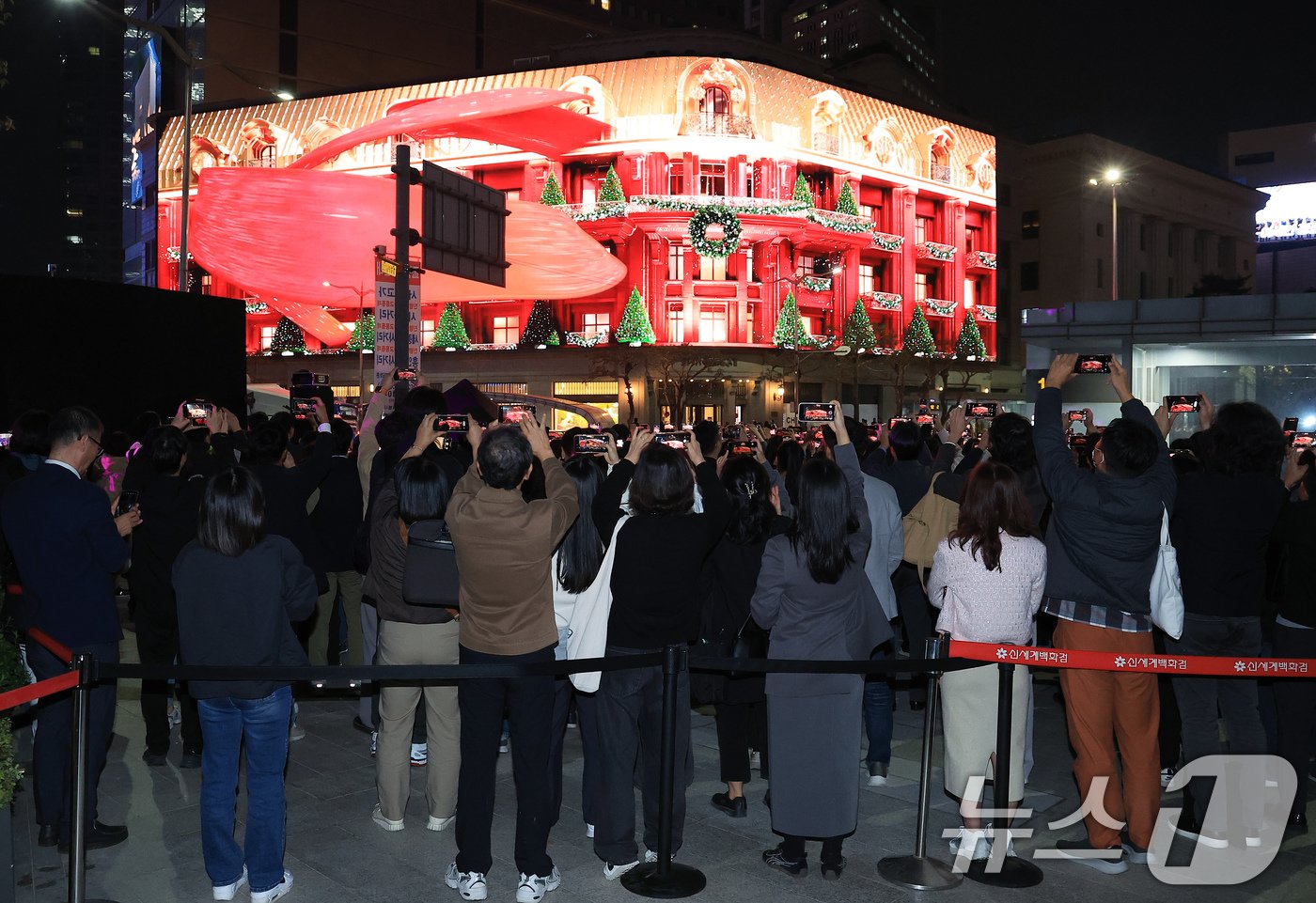 본문 이미지 - 1일 오후 서울 중구 신세계백화점 본점 앞을 찾은 시민들이 외벽에 설치된 LED 사이니지 '신세계스퀘어'에서 펼쳐진 미디어 파사드를 휴대전화로 촬영하고 있다. 1963년 대한민국 최초 백화점을 연 신세계는 가로 72m, 높이 18m, 농구장 3개 크기(1292.3㎡)의 초대형 디지털 LED 사이니지 '신세계스퀘어'를 통해 이날 '크리스마스의 순간들을 찾아서'라는 주제의 4분여가량인 미디어 파사드를 선보였다. '신세계스퀘어'는 상시 운영을 통해 연중 다채로운 빛의 향연을 펼칠 예정이다. 2024.11.1/뉴스1 ⓒ News1 박정호 기자
