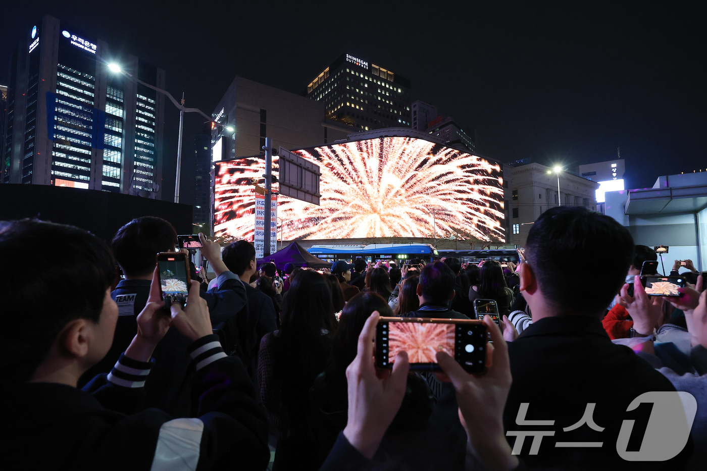 (서울=뉴스1) 박정호 기자 = 1일 오후 서울 중구 신세계백화점 본점 앞을 찾은 시민들이 외벽에 설치된 LED 사이니지 '신세계스퀘어'에서 펼쳐진 미디어 파사드를 휴대전화로 촬영 …