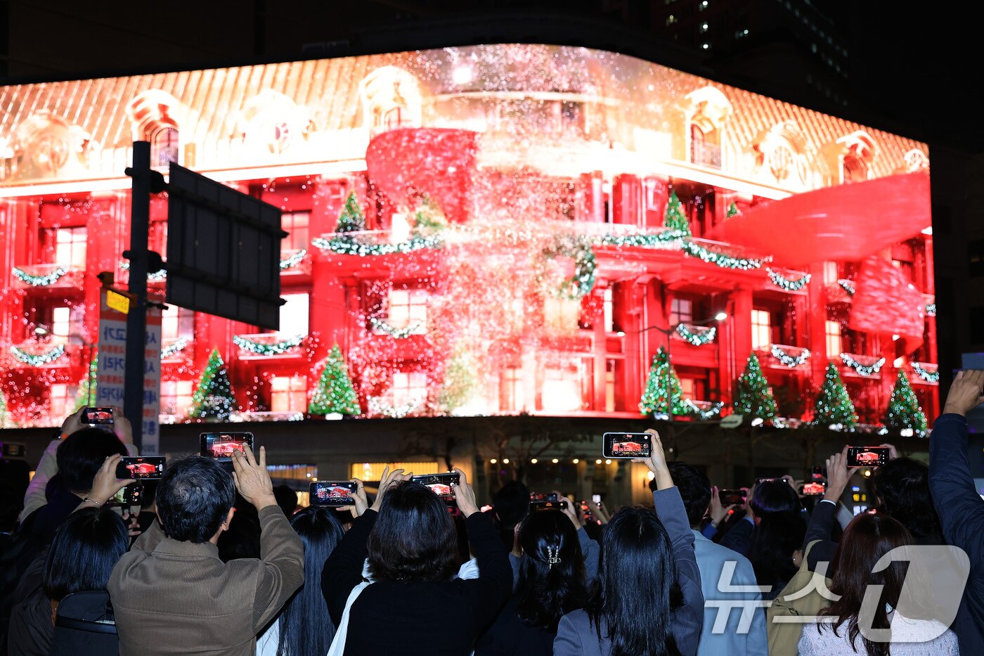 본문 이미지 - 지난해 11월 1일 서울 중구 신세계백화점 본점 앞을 찾은 시민들이 외벽에 설치된 LED 사이니지 &#39;신세계스퀘어&#39;에서 펼쳐진 미디어 파사드를 휴대전화로 촬영하고 있다. 2024.11.1/뉴스1 ⓒ News1 박정호 기자