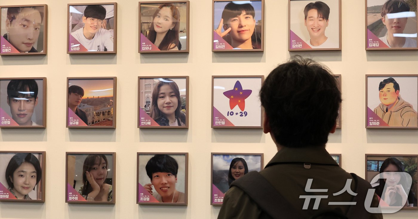 본문 이미지 - 10일 서울 종로구 적선현대빌딩에 열린 &#39;10·29 이태원 참사 기억·소통공간 이전 &#39;별들의 집&#39; 개소식에서 한 관계자가 희생자들의 사진을 바라보고 있다. 2024.11.10/뉴스1 ⓒ News1 김성진 기자