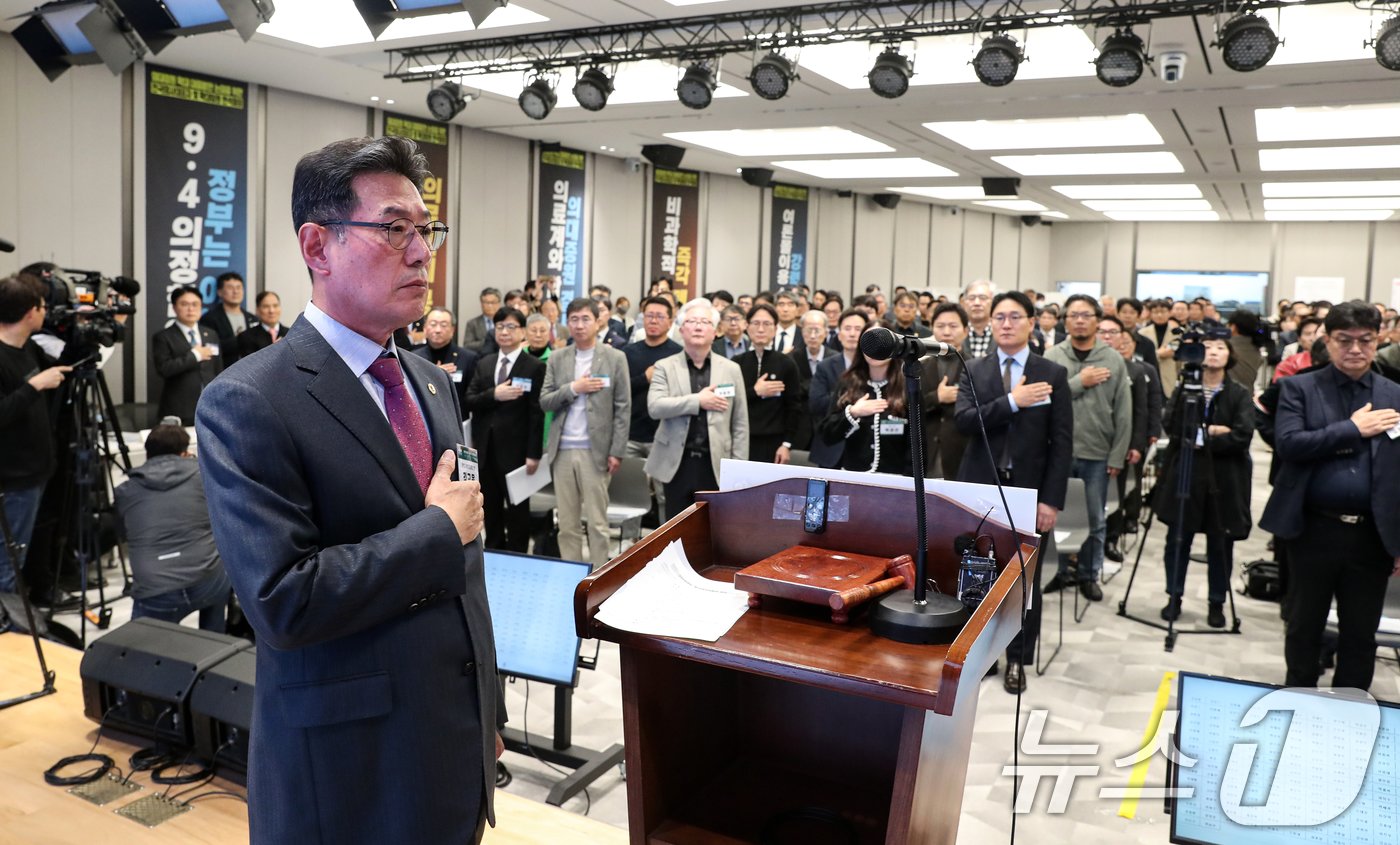 10일 오후 서울 용산구 대한의사협회에서 열린 긴급 임시 대의원 총회에서 김교웅 대한의사협회 대의원회 의장을 비롯한 참석자들이 국민의례하고 있다. 대한의사협회는 이날 대의원총회를 통해 &#39;막말 논란&#39; &#39;1억원 합의금 요구&#39; 등으로 논란을 빚어온 임현택 대한의사협회장의 탄핵 여부를 결정할 예정이다. 2024.11.10/뉴스1 ⓒ News1 이승배 기자