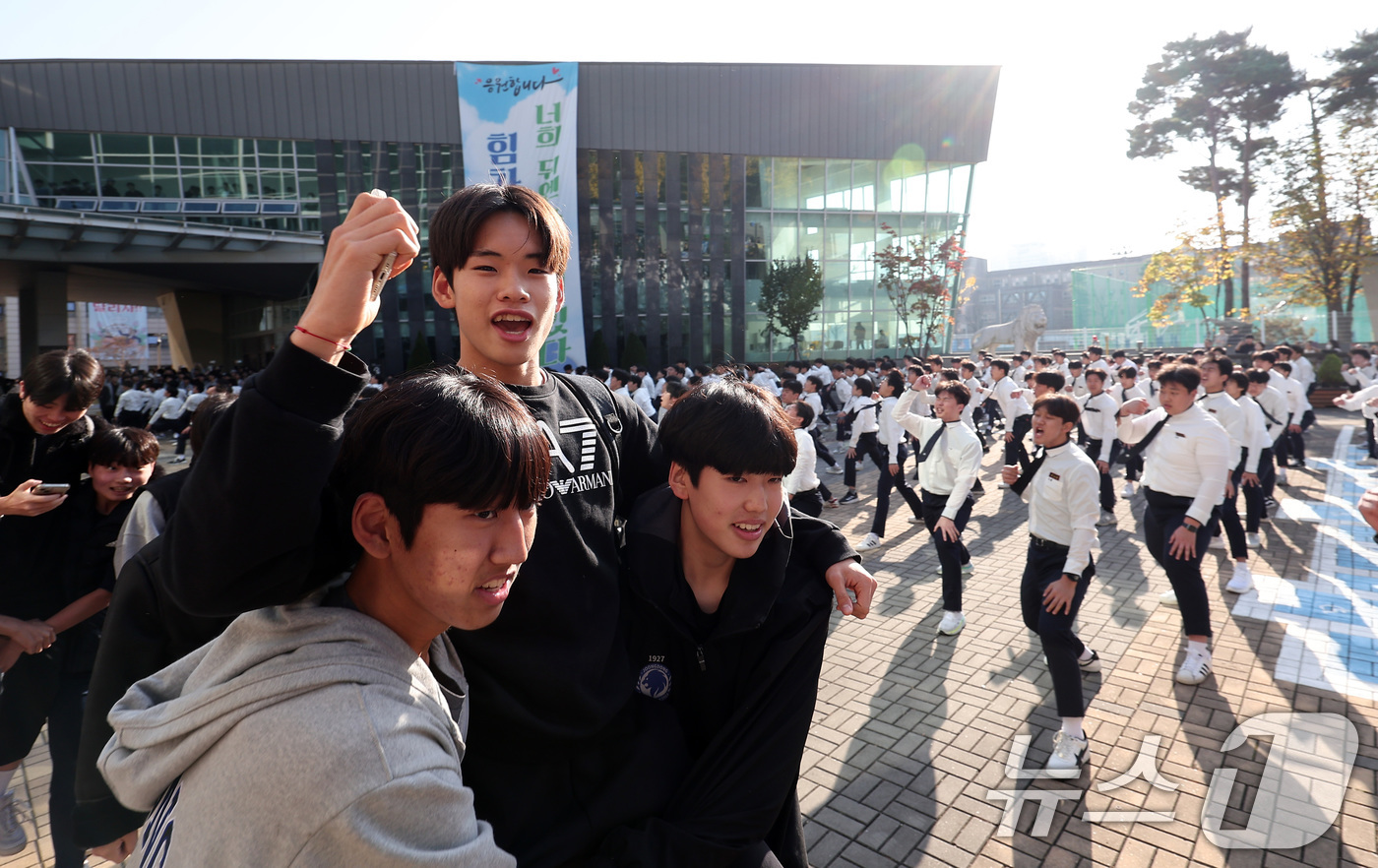 (서울=뉴스1) 김성진 기자 = 2025학년도 대학수학능력시험을 하루 앞둔 13일 서울 강남구 중동고등학교에서 한 수험생이 재학생들의 응원을 받으며 하교하고 있다. 2024.11. …