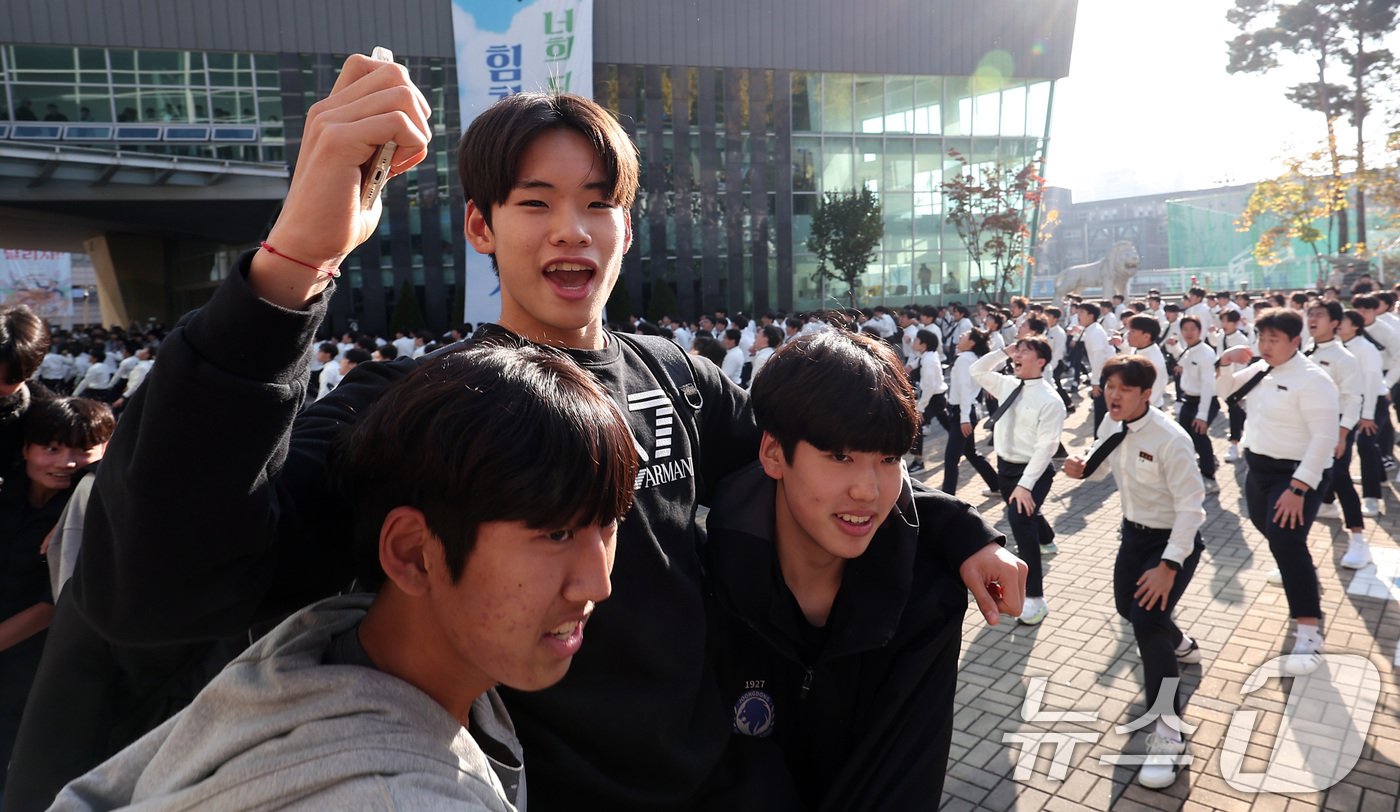 (서울=뉴스1) 김성진 기자 = 2025학년도 대학수학능력시험을 하루 앞둔 13일 서울 강남구 중동고등학교에서 한 수험생이 재학생들의 응원을 받으며 하교하고 있다. 2024.11. …