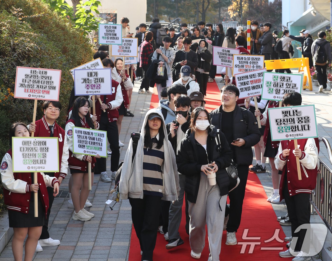 2025학년도 대학수학능력시험을 하루 앞둔 13일 오전 경기 용인시 수지구 죽전고등학교 정문 진입로에 학생회가 준비한 &#39;레드카펫&#39; 길로 3학년 학생들이 후배들의 응원을 받으며 하교를 하고 있다. 2024.11.13/뉴스1 ⓒ News1 김영운 기자