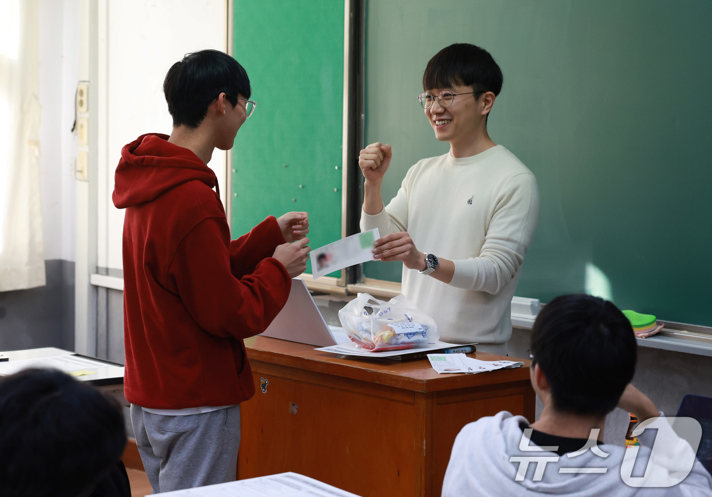 (서울=뉴스1) 임세영 기자 = 2025학년도 대학수학능력시험 예비소집일인 13일 서울 종로구 중앙고등학교에서 3학년 학생들이 교사로부터 수험표를 배부받고 있다. (공동취재) 20 …
