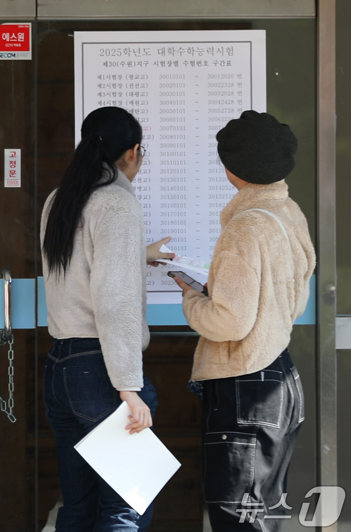 (수원=뉴스1) 김영운 기자 = 2025학년도 대학수학능력시험을 하루 앞둔 13일 오후 경기 수원시 팔달구 수원여자고등학교에서 수험생들이 시험실 배치표를 보고 있다. 2024.11 …