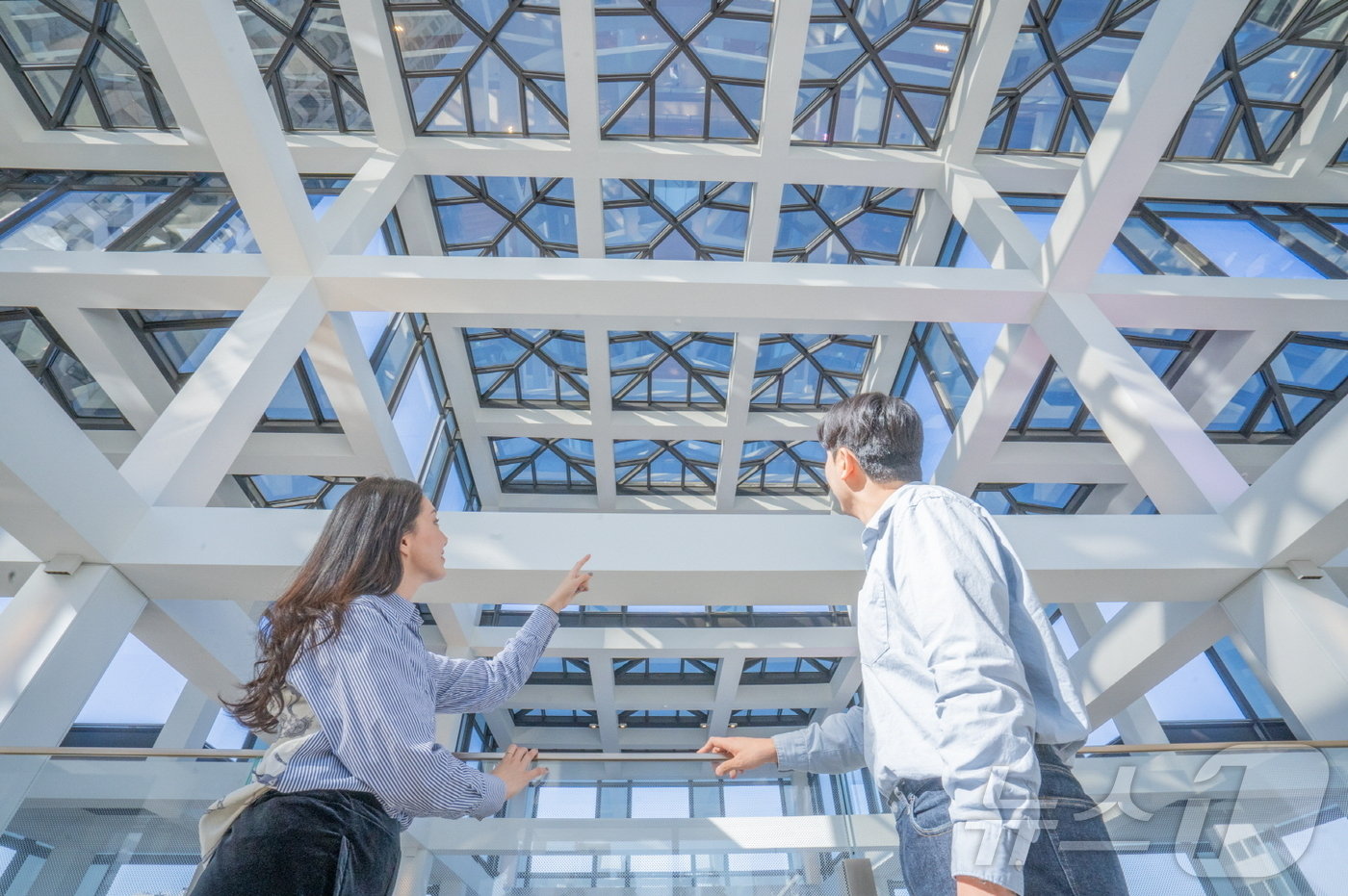 본문 이미지 - LG트윈타워에서 근무하는 직원들이 건물 디자인에 반영된 아트리움 골조의 문창살과 우물살 패턴을 관찰하고 있다&#40;LG 제공&#41;. ⓒ 뉴스1