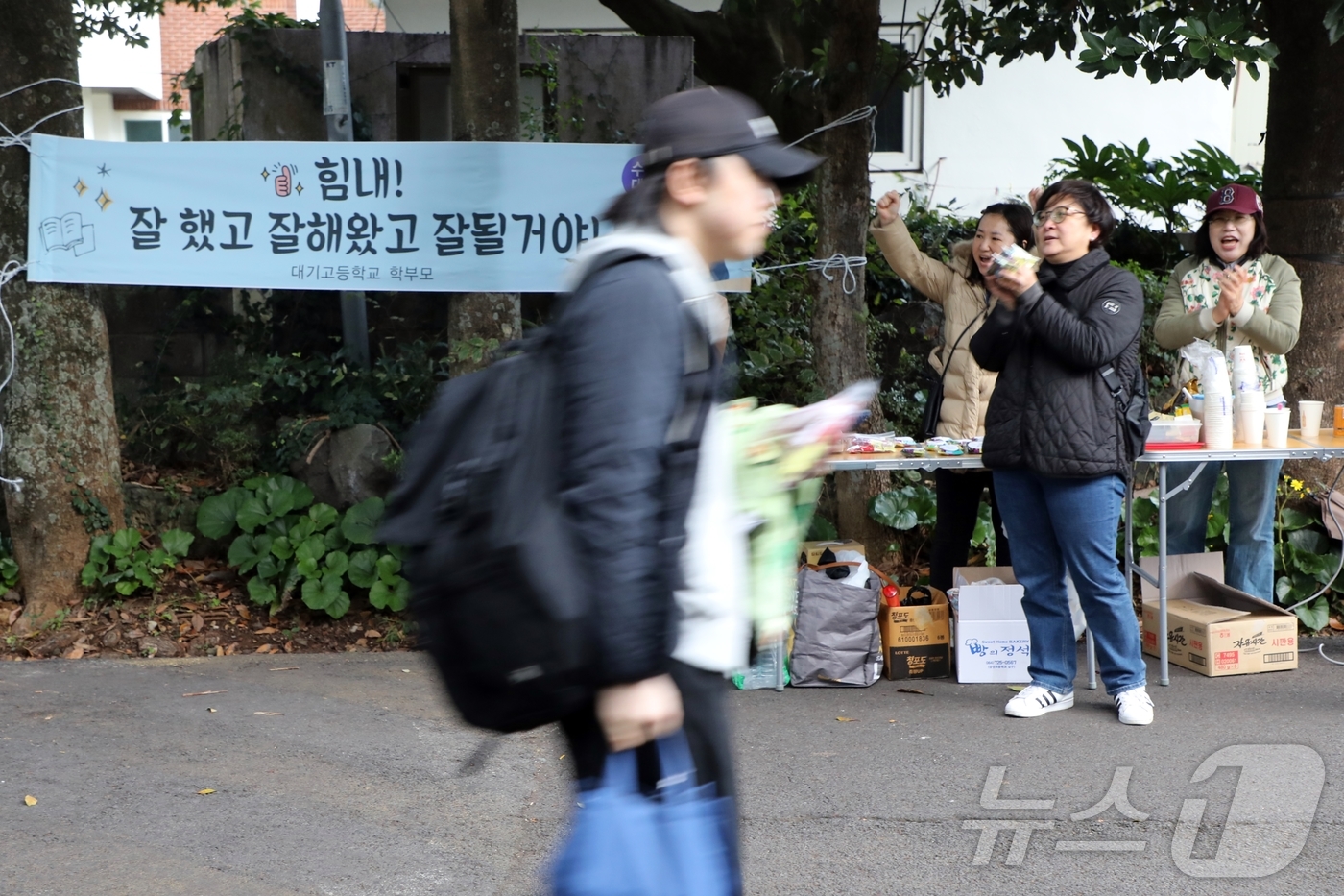 (제주=뉴스1) 홍수영 기자 = 14일 제주도교육청 제95지구 제4시험장 대기고등학교에서 수험생들이 응원을 받으며 들어가고 있다.2024.11.14/뉴스1