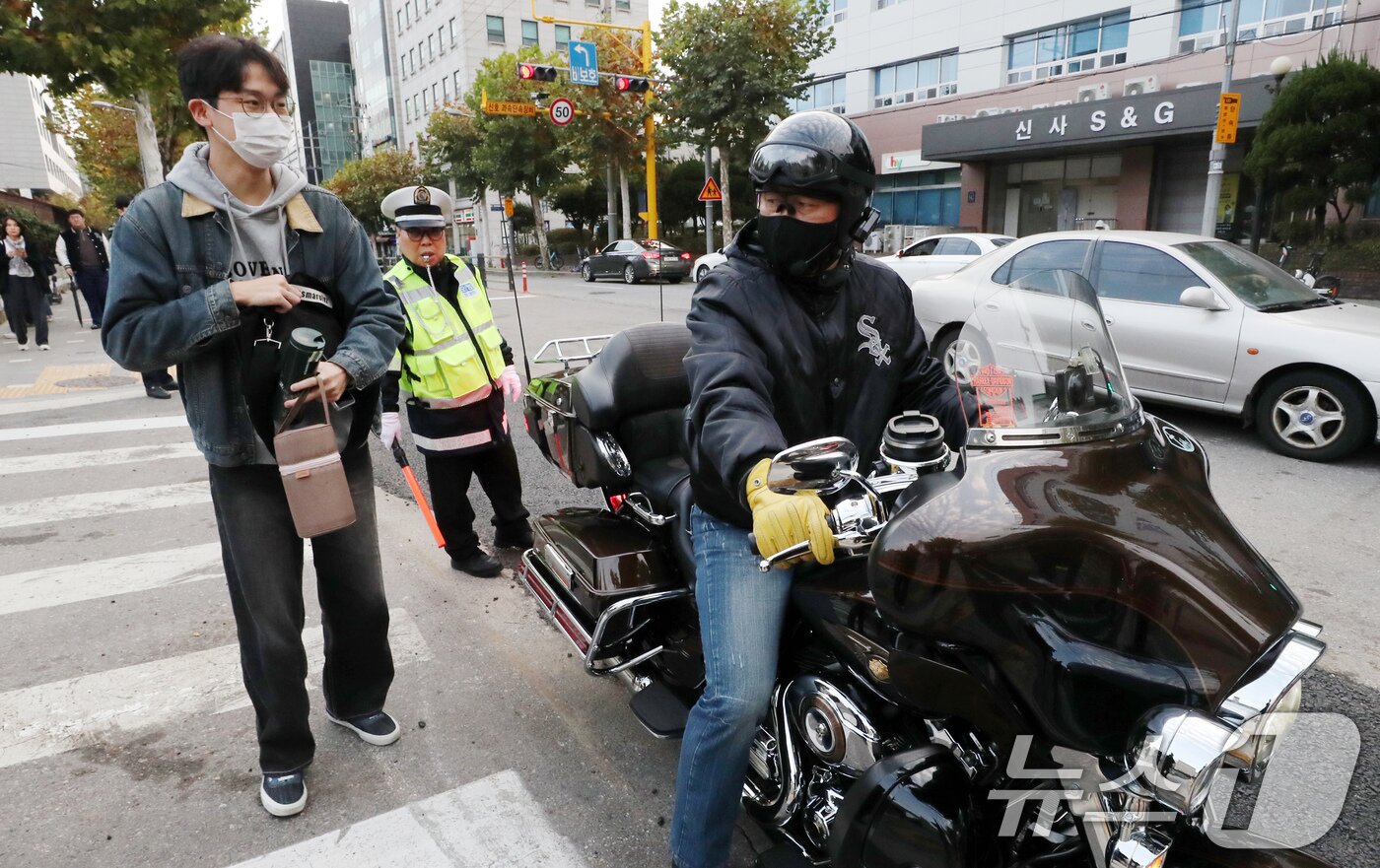 본문 이미지 - 2025학년도 대학수학능력시험일인 14일 오전 서울시교육청 18지구 제1시험장인 서울 강남구 휘문고등학교 앞에서 한 수험생이 오토바이로 시험장에 태워준 아버지와 입실 전 대화를 나누고 있다. 2024.11.14/뉴스1 ⓒ News1 박세연 기자