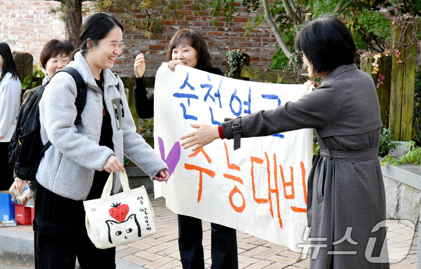 (순천=뉴스1) 김동수 기자 = 2025학년도 대학수학능력시험일인 14일 오전 전라남도교육청 75지구 제6시험장인 순천매산여자고등학교 앞에서 교사와 수험생들이 기뻐하고 있다.202 …