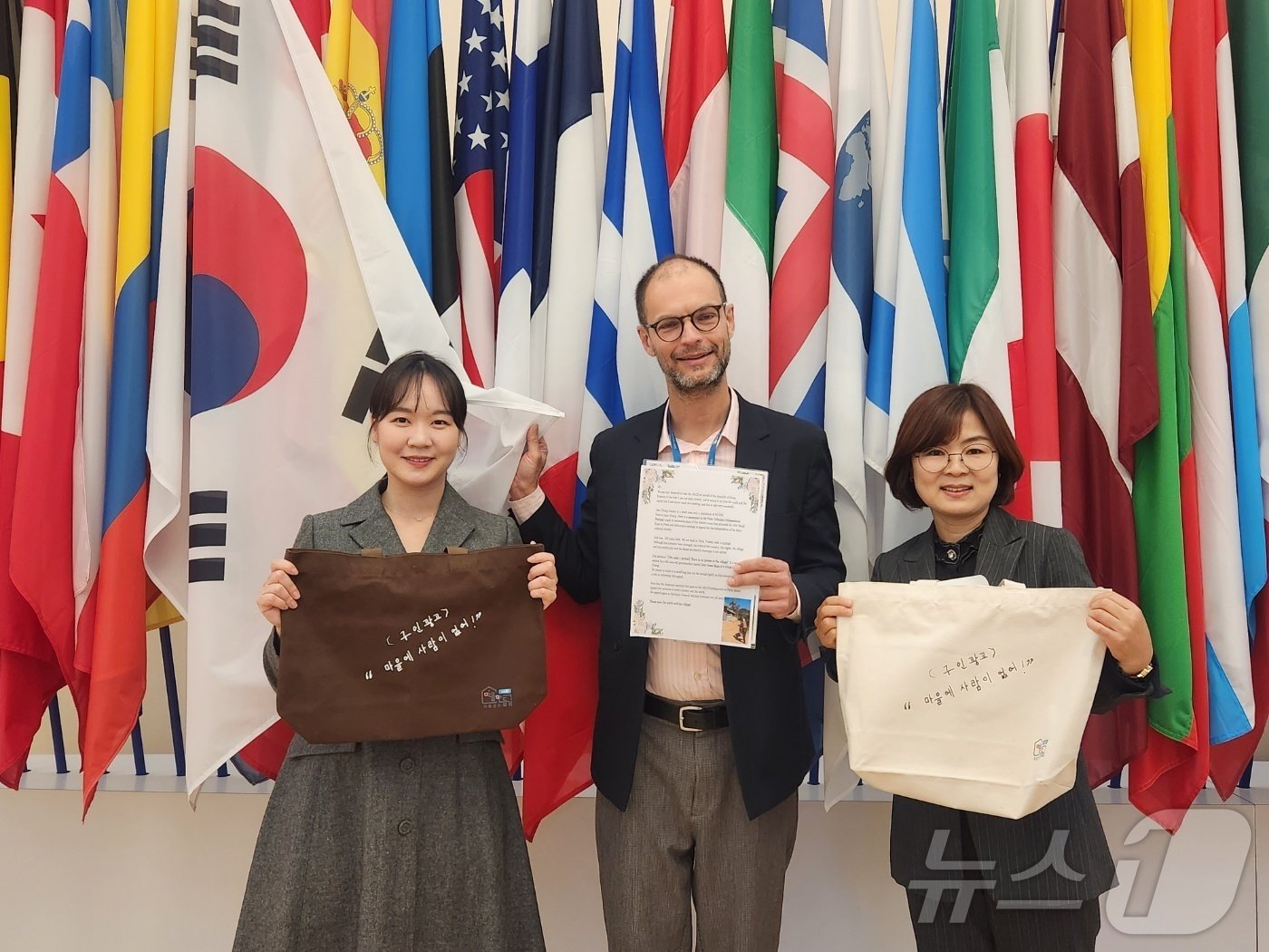 본문 이미지 - 거창군 직원들이 지난 12일 최금분 할머니의 손 글씨 에코백과 호소문을 프랑스 파리 경제협력개발기구 본부에 전달하고 있다. 2024.11.12