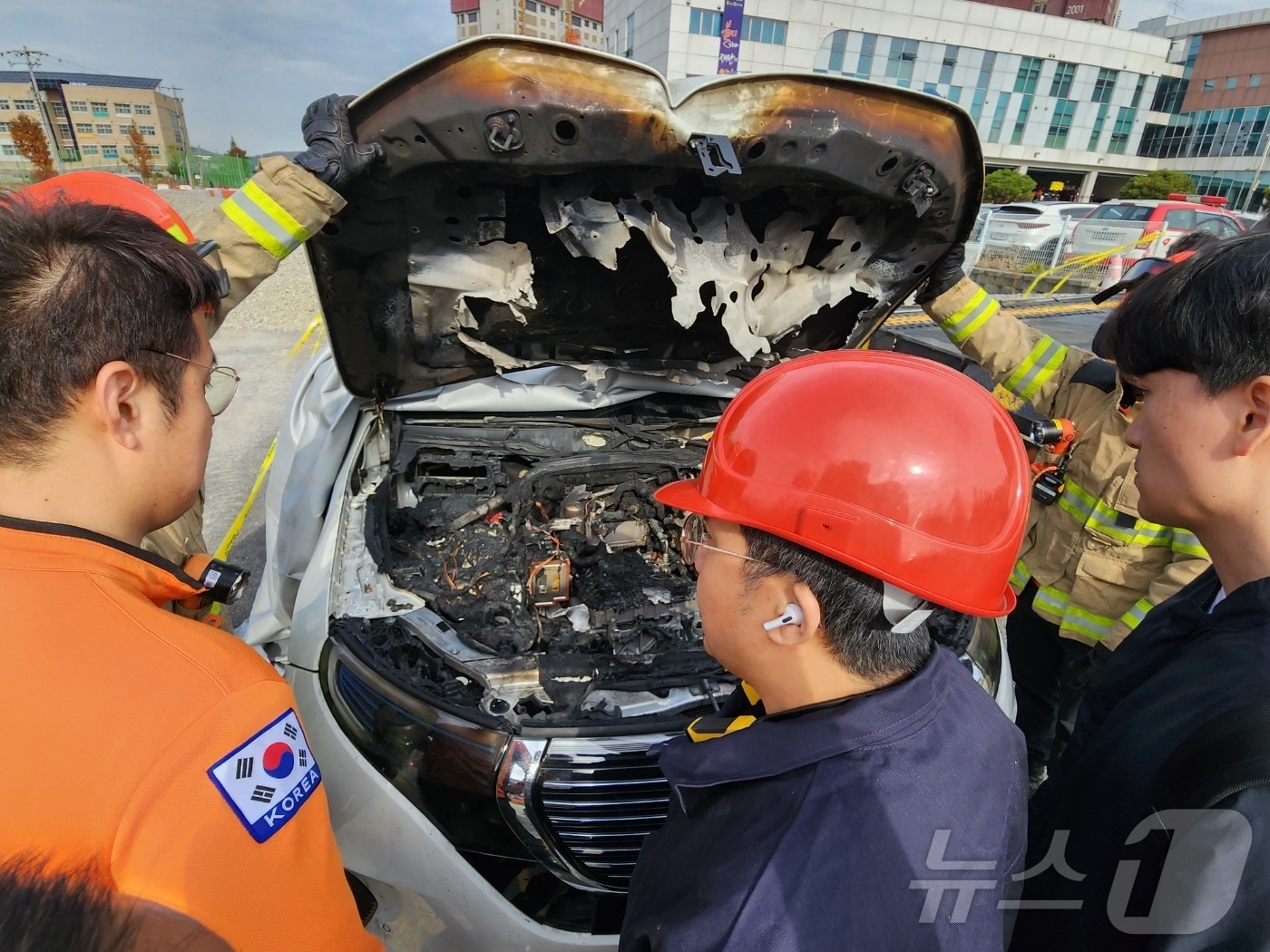 (천안=뉴스1) 이시우 기자 = 14일 충남 아산시 모종동에서 불에 탄 벤츠 EQC400 차량의전원을 차단하기 위해 소방당국 및 제조사 관계자 등이 내부를 살펴보고 있다. 2024 …