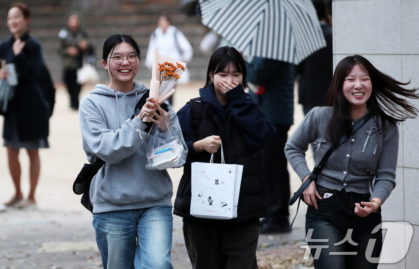 (서울=뉴스1) 오대일 기자 = 14일 오후 서울 중구 이화여자외국어고등학교에서 2025학년도 대학수학능력시험을 마친 수험생들이 축하 꽃다발을 받아 들고 고사장을 나서고 있다.수능 …