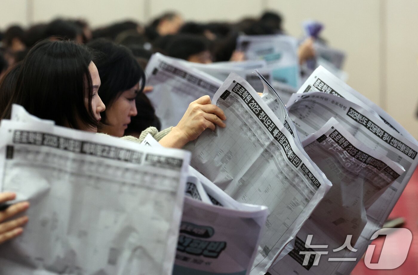 본문 이미지 - 15일 서울 광진구 세종대학교에서 열린 종로학원 2025 정시 합격점수 예측 및 전략 설명회에서 학부모들이 정시모집 배치 참고표를 보며 설명을 듣고 있다. 2024.11.15/뉴스1 ⓒ News1 김명섭 기자