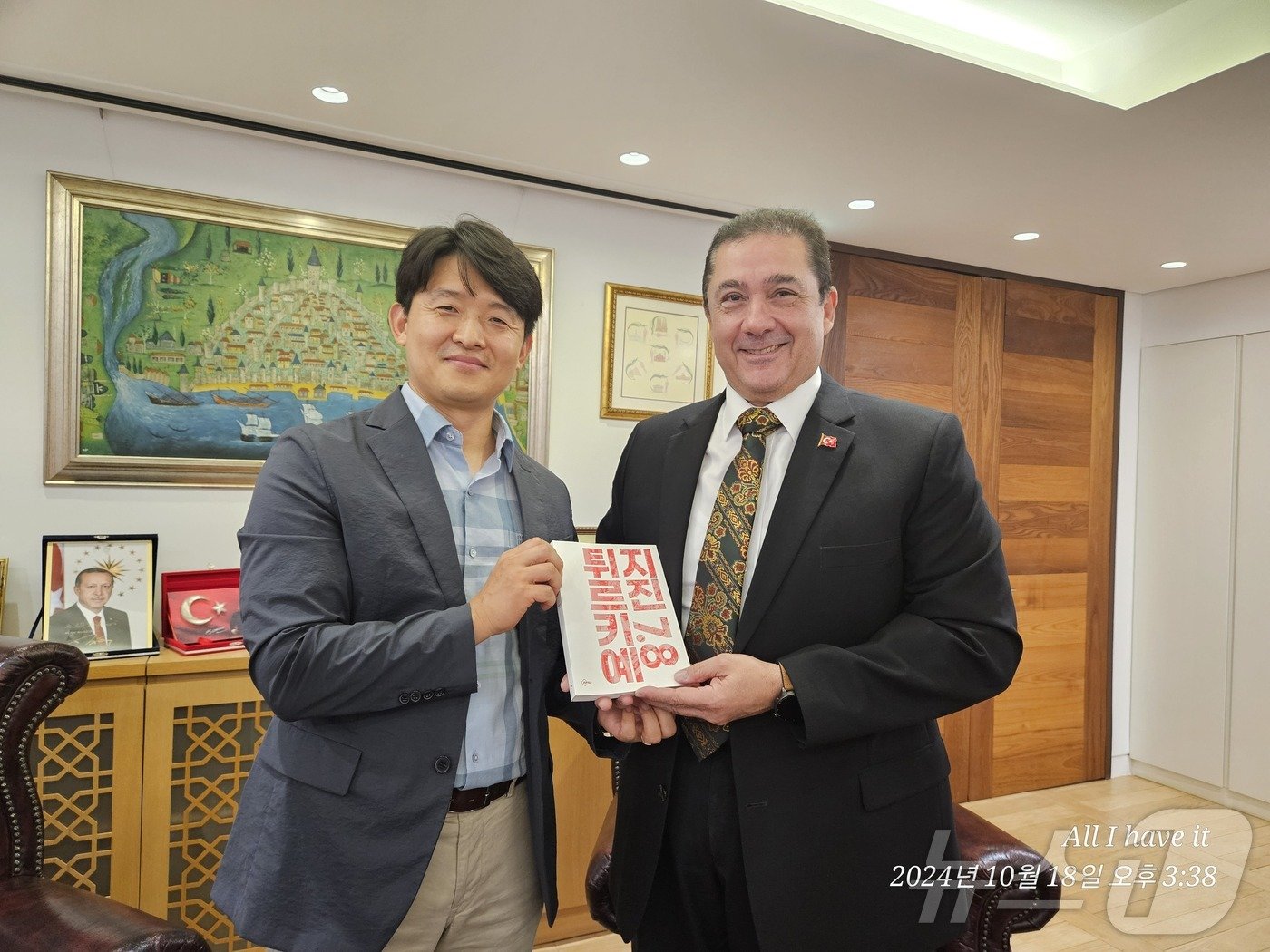 본문 이미지 - 김상호 소방장이 살리 무랏 타메르 주한 튀르키예 대사에게 책을 소개한 후 기념사진을 촬영하고 있다.(김상호 소방장 제공) /뉴스1