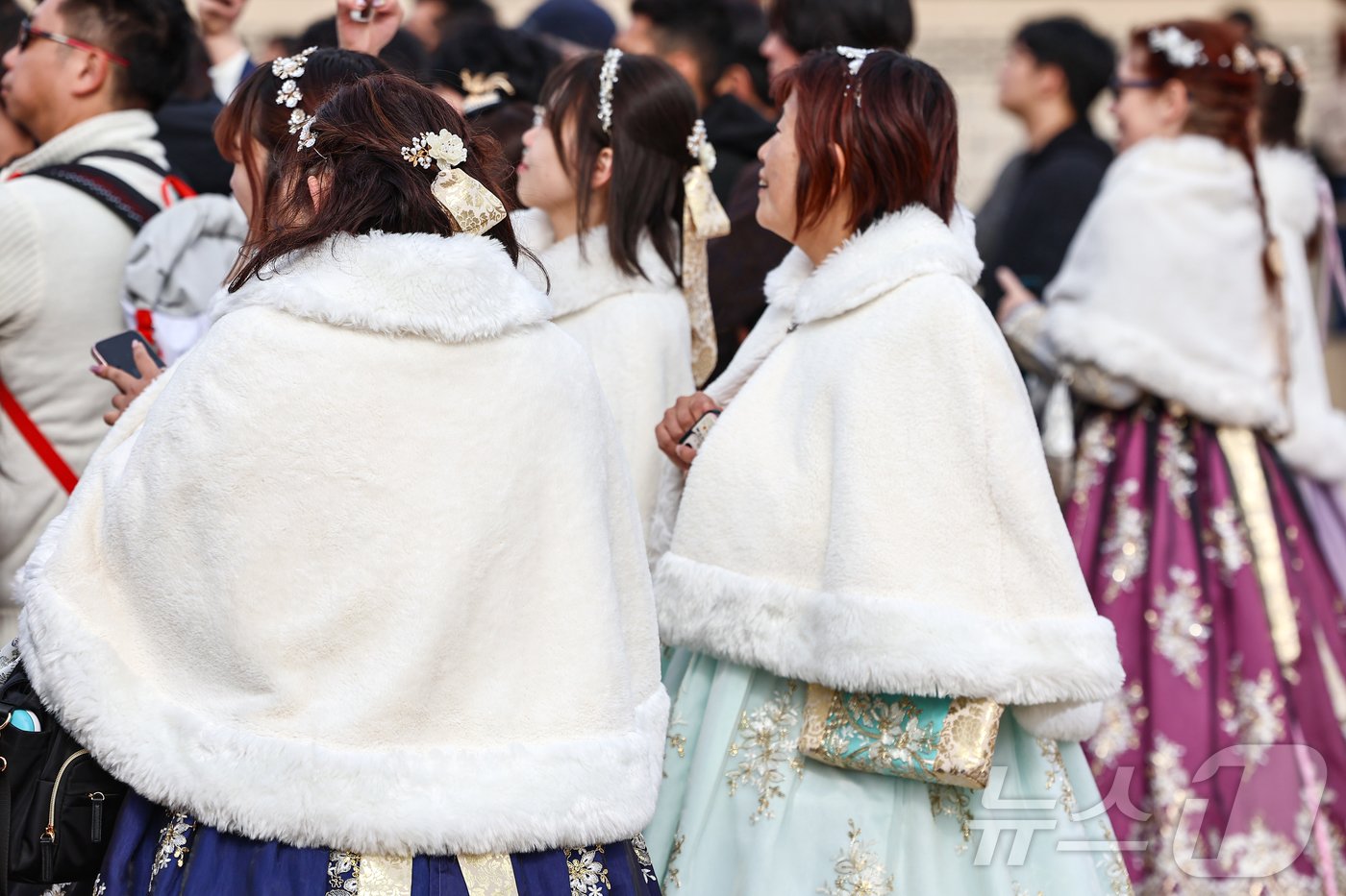 본문 이미지 - 비가 그치고 기온이 급격히 떨어진 17일 서울 종로구 경복궁에서 외국인 관광객들이 한복 위에 털망토를 두른 채 관람을 하고 있다. 2024.11.17/뉴스1 ⓒ News1 김도우 기자