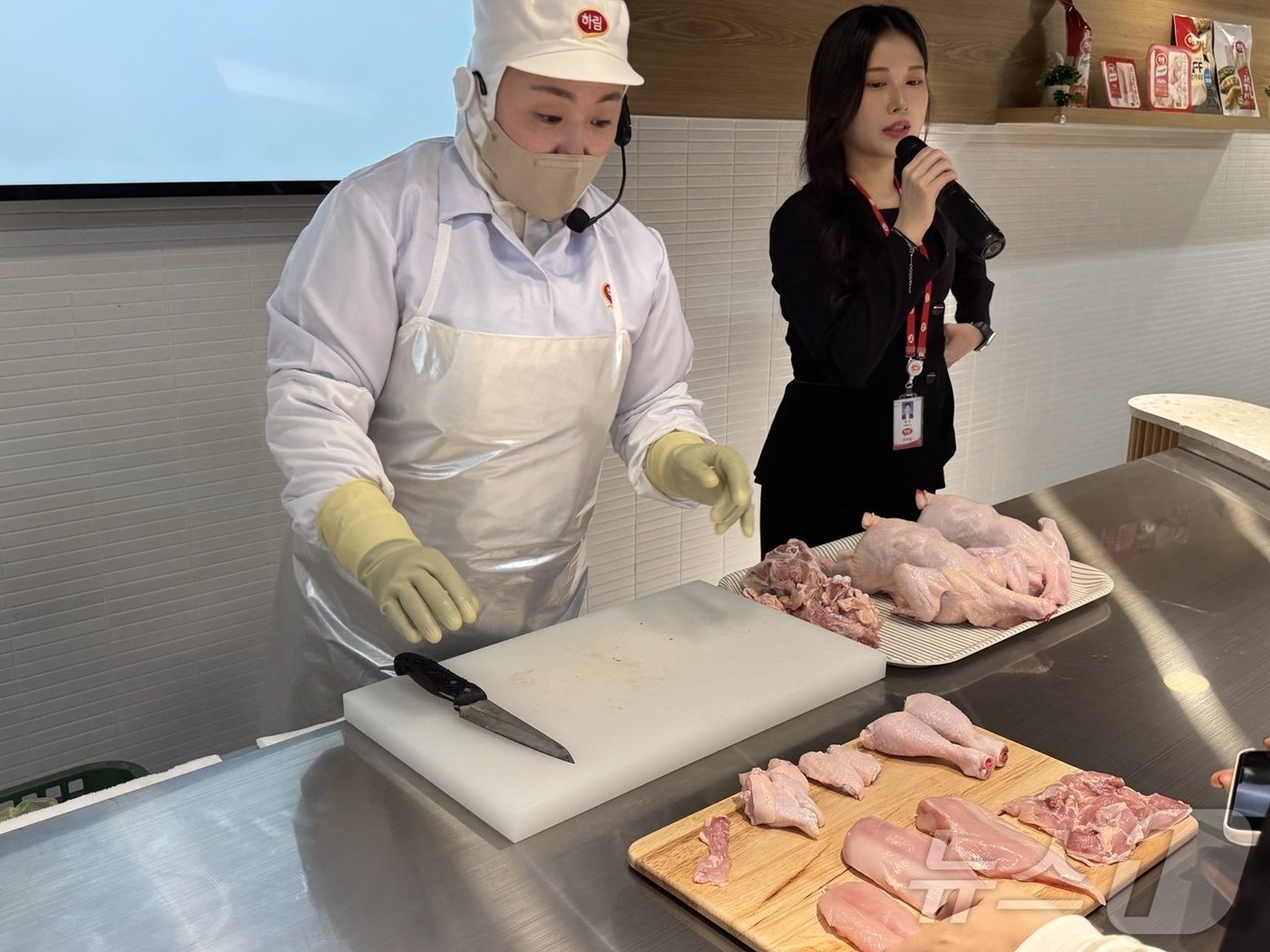 &#39;치킨로드&#39; 투어 신선공장에서 발골 전문가&#40;왼쪽&#41;가 닭 한 마리를 해체하고 있는 가운데, 도슨트&#40;오른쪽&#41;이 설명을 보태고 있다.2024.11.15/ⓒ News1 이강 기자