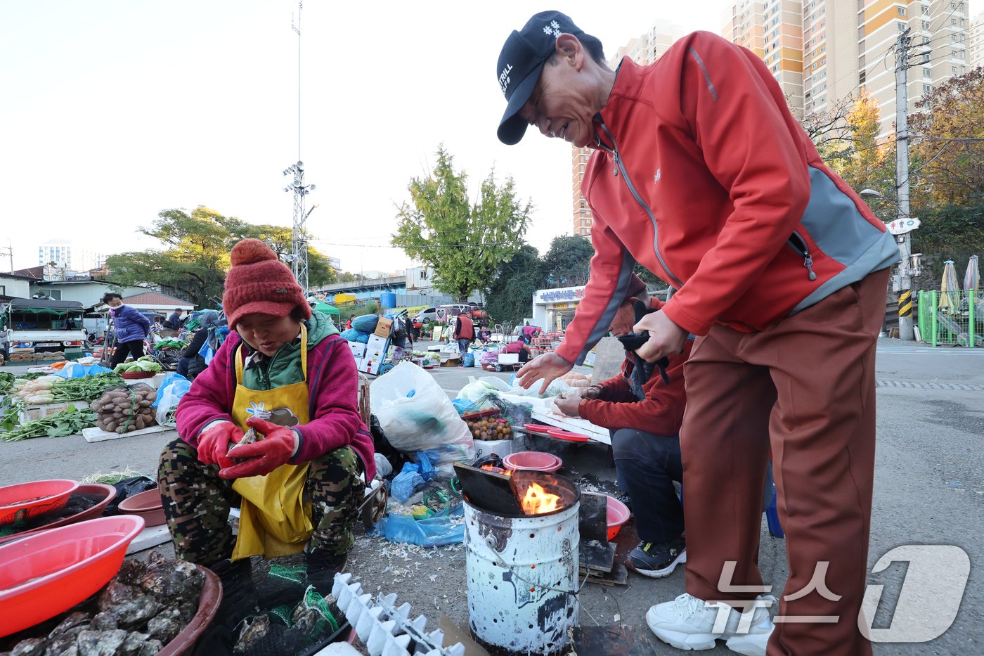 18일 아침기온이 큰 폭으로 떨어지면서 올해 가장 추운 날씨를 보인 광주 남광주시장에서 상인들이 모닥불을 피워놓으니 지나가는 시민도 잠시 추위를 녹이고 있다. 2024.11.18/뉴스1 ⓒ News1 김태성 기자