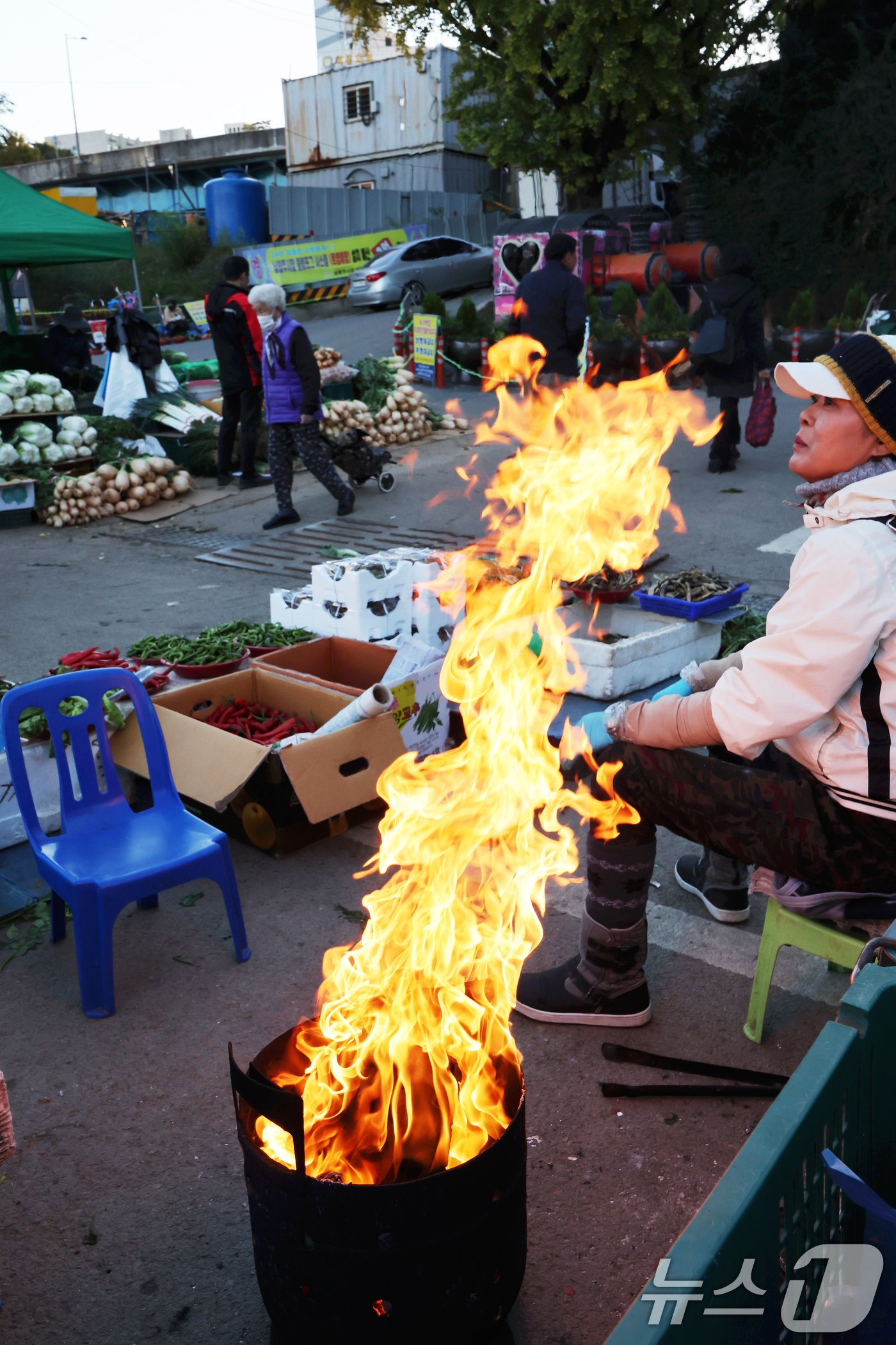 18일 아침기온이 큰 폭으로 떨어지면서 올해 가장 추운 날씨를 보인 광주 남광주시장에서 한 상인이 피워놓은 모닥불이 높이 솟아 오르고 있다. 2024.11.18/뉴스1 ⓒ News1 김태성 기자