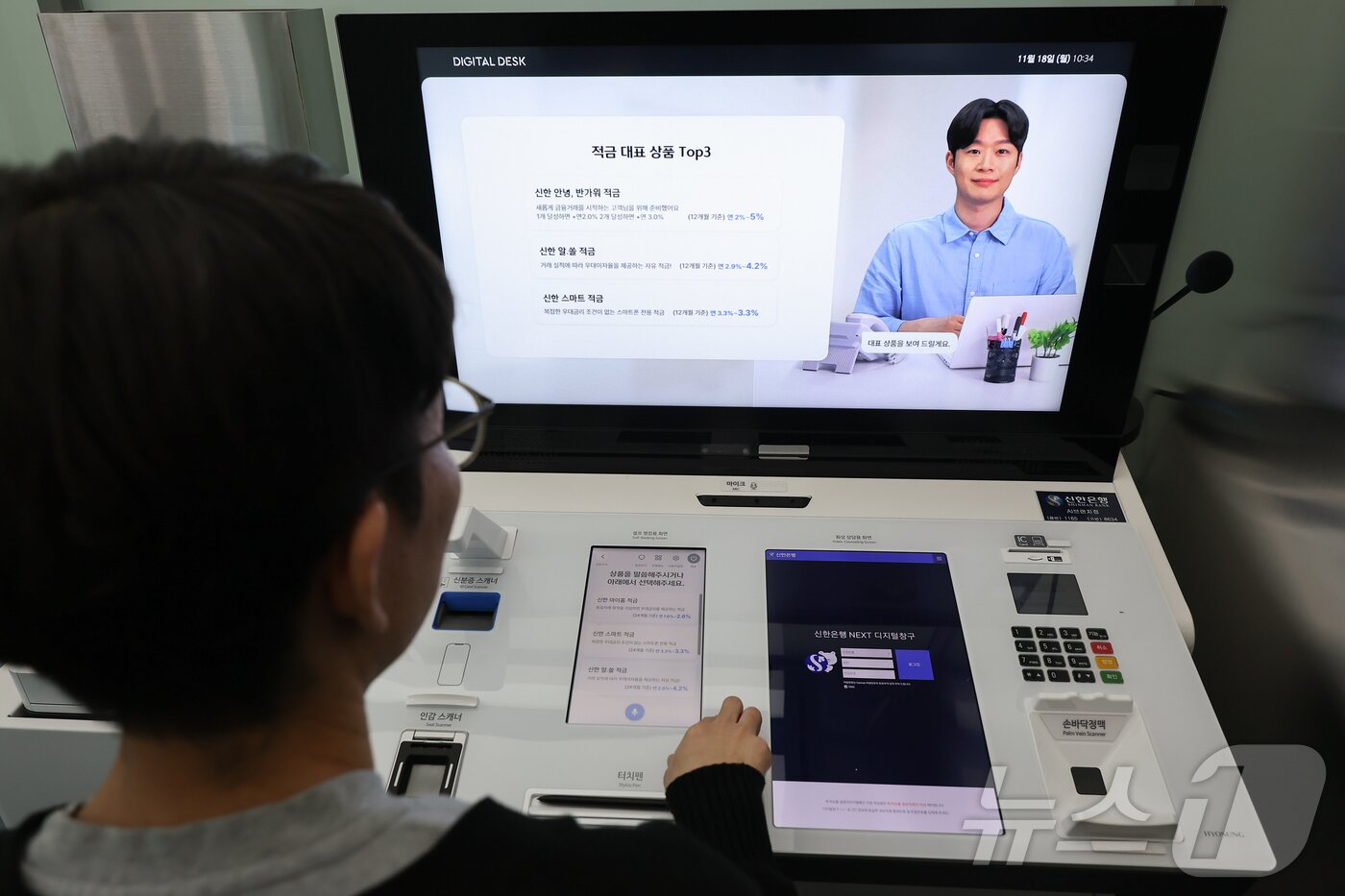 본문 이미지 - 서울 중구 신한은행 서소문지점 AI 브랜치에서 직원이 AI은행원과 상담업무를 시연하고 있다. /뉴스1 ⓒ News1 김도우 기자