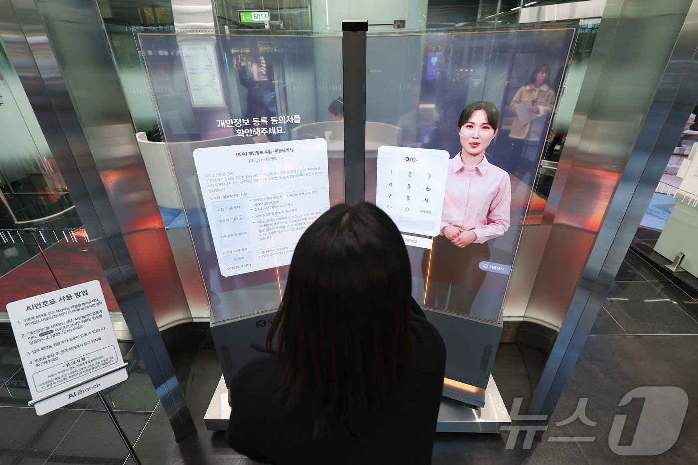 본문 이미지 - 18일 서울 중구 신한은행 서소문지점 AI 브랜치에서 직원이 AI은행원과 상담업무를 시연하고 있다. 2024.11.18/뉴스1 ⓒ News1 김도우 기자