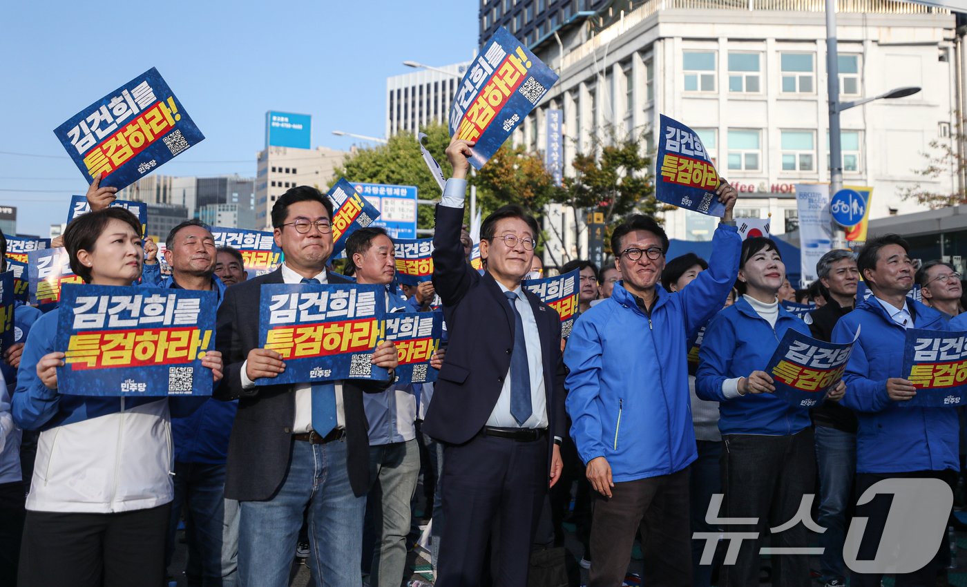 이재명 더불어민주당 대표가 2일 오후 서울 중구 서울역 인근에서 열린 ‘김건희 국정농단 범국민 규탄대회’에서 박찬대 원내대표, 김민석 최고위원을 비롯한 주요 참석자들과 손펫말을 들어보이고 있다. 2024.11.2/뉴스1 ⓒ News1 이승배 기자