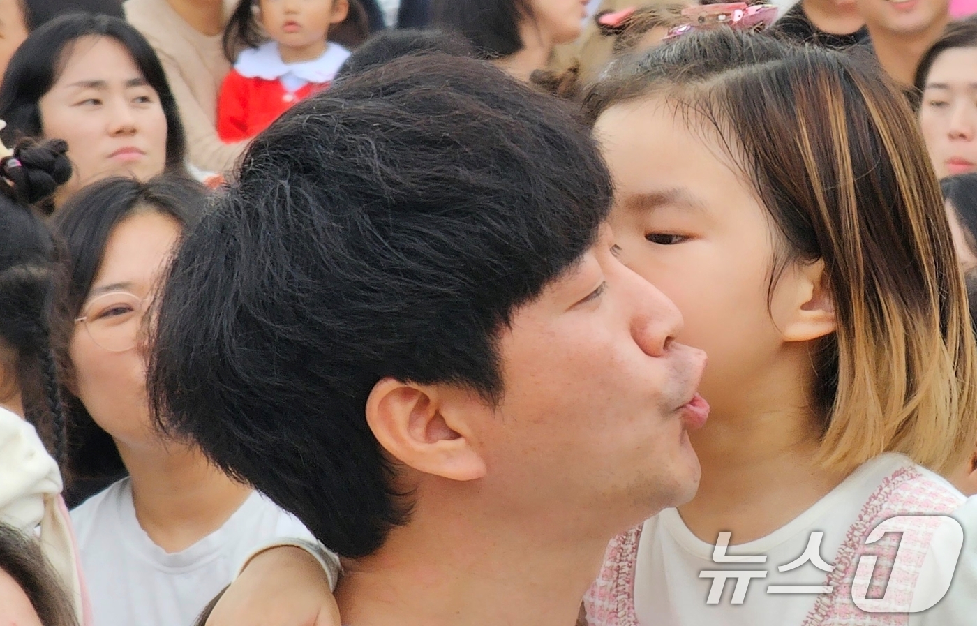 (구미=뉴스1) 정우용 기자 = 구미 라면축제 연계행사로 금오산 잔디광장에서 2일 열린 '캐치 티닝핑' 콘서트에 참여한 한 어린이가 티니핑 노래에 맞춰 엄마·아빠의 볼에 뽀뽀하고 …