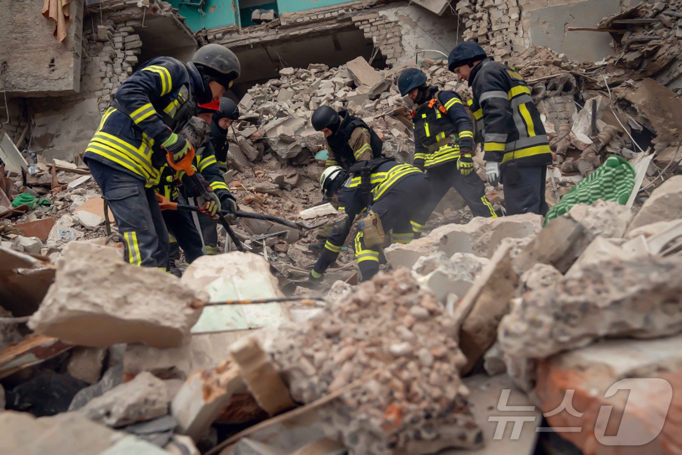 본문 이미지 - 19일(현지시간) 우크라이나 수미의 흘루히우에서 러시아 군의 미사일 공격을 받아 허물어진 건물서 구조대원이 수색을 하고 있다. 2024.11.20 ⓒ AFP=뉴스1 ⓒ News1 우동명 기자