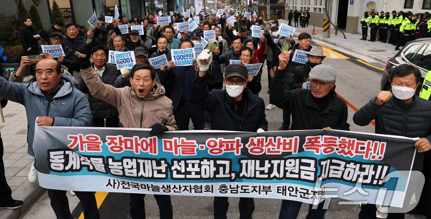 (서울=뉴스1) 이동해 기자 = 20일 오후 서울 중구 농협중앙회 본점 인근에서 열린 전국마늘양파생산자대표자대회에서 양파 모종을 든 참가자들이 재난지원금 지급 등을 촉구하고 있다. …