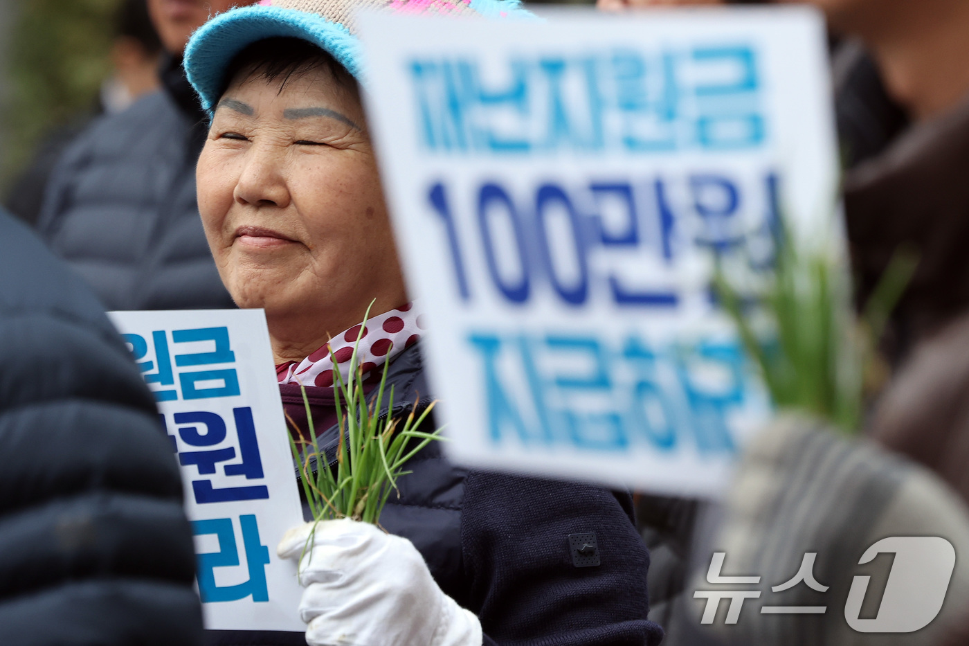 (서울=뉴스1) 이동해 기자 = 20일 오후 서울 중구 농협중앙회 본점 인근에서 열린 전국마늘양파생산자대표자대회에서 양파 모종을 든 참가자들이 재난지원금 지급 등을 촉구하고 있다. …