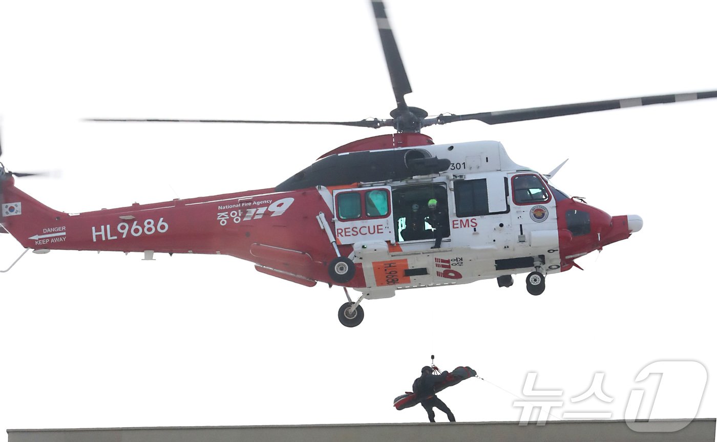 본문 이미지 - 20일 전주시 덕진구 팔복LH아파트 및 더 메이호텔에서 행정안전부를 비롯한 전북소방본부, LH 등이 참여한 가운데 열린 유관기관합동 전기차 화재 대응 제4차 READY Korea 훈련에서 소방청 헬기를 이용하여 호텔 옥상에 고립된 환자를 이송하고 있다. 2024.11.20/뉴스1 ⓒ News1 김기남 기자