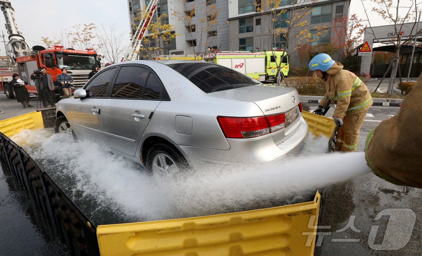 본문 이미지 - 20일 전주시 덕진구 팔복LH아파트 및 더 메이호텔에서 행정안전부를 비롯한 전북소방본부, LH 등이 참여한 가운데 열린 유관기관합동 전기차 화재 대응 제4차 READY Korea 훈련에서 소방대원들이 화재 진압한 전기차를 이동식 소화수조에 넣고 있다. 2024.11.20/뉴스1 ⓒ News1 김기남 기자