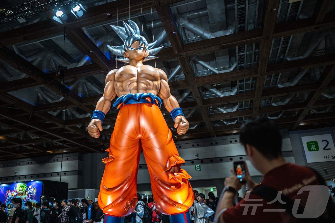본문 이미지 - 일본 도쿄 빅사이트에서 개최된 '드래곤볼 40주년 대축제' 행사장에서 원작 팬들이 주인공 손오공 모형을 촬영하고 있다. 2024.11.20/ ⓒ AFP=뉴스1 ⓒ News1 권진영 기자
