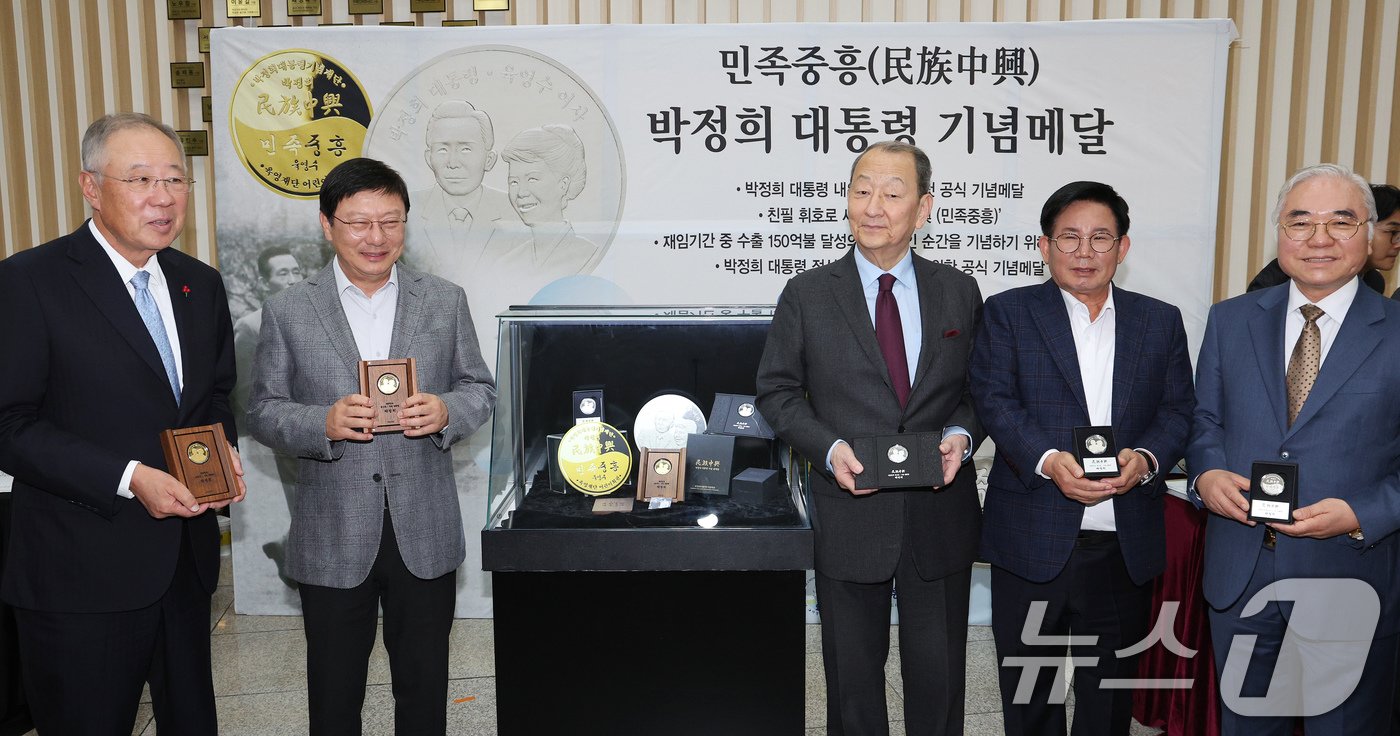 본문 이미지 - 박지만 EG 회장(왼쪽 두번째)이 20일 오후 서울 마포구 마포아트센터에서 박정희 전 대통령과 육영수 여사의 첫 공식 기념메달 공개행사에서 류진 한국경제인협회 회장(왼쪽), 류영구 박정희대통령기념재단 이사장(왼쪽 세번째) 등 참석 인사들과 기념메달을 들어 보이고 있다. 2024.11.20/뉴스1 ⓒ News1 장수영 기자