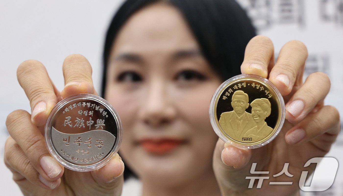 본문 이미지 - 20일 오후 서울 마포구 마포아트센터에서 모델이 박정희 전 대통령과 육영수 여사의 첫 공식 기념메달을 들어보이고 있다. 2024.11.20/뉴스1 ⓒ News1 장수영 기자
