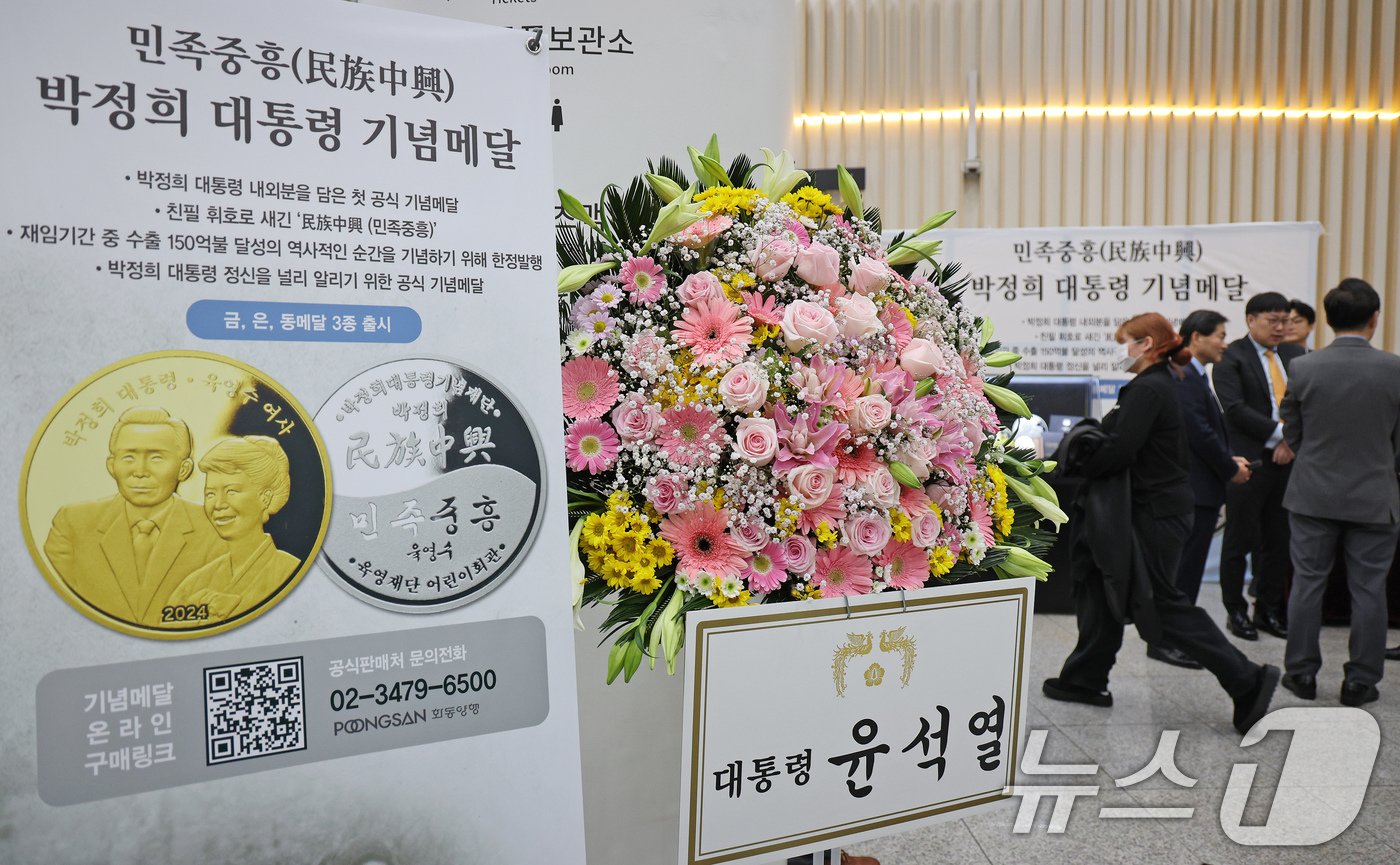 본문 이미지 - 20일 오후 서울 마포구 마포아트센터에서 열린 박정희 전 대통령과 육영수 여사의 첫 공식 기념메달 공개 행사장에 윤석열 대통령의 축하 화환이 놓여 있다. 2024.11.20/뉴스1 ⓒ News1 장수영 기자