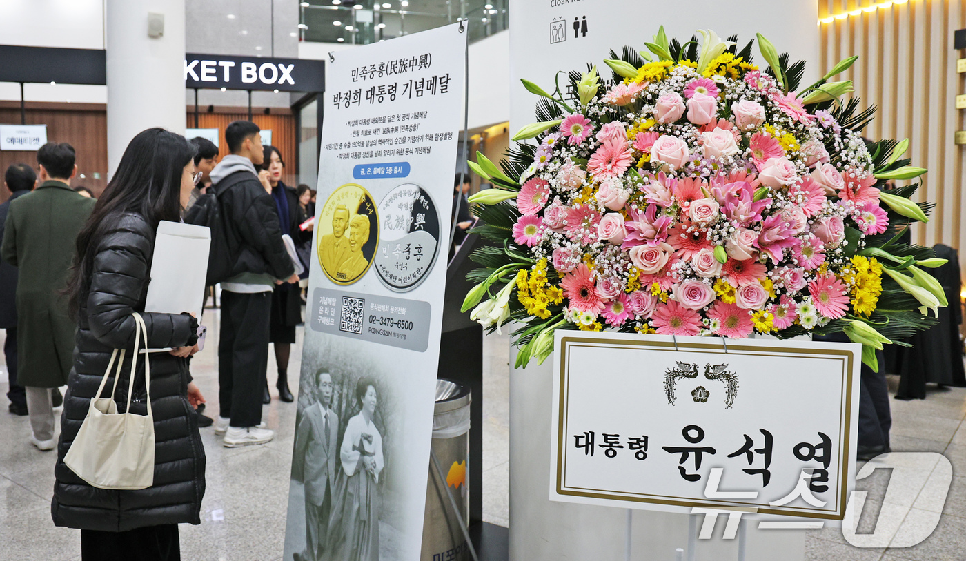 (서울=뉴스1) 장수영 기자 = 20일 오후 서울 마포구 마포아트센터에서 열린 박정희 전 대통령과 육영수 여사의 첫 공식 기념메달 공개 행사장에 윤석열 대통령의 축하 화환이 놓여 …