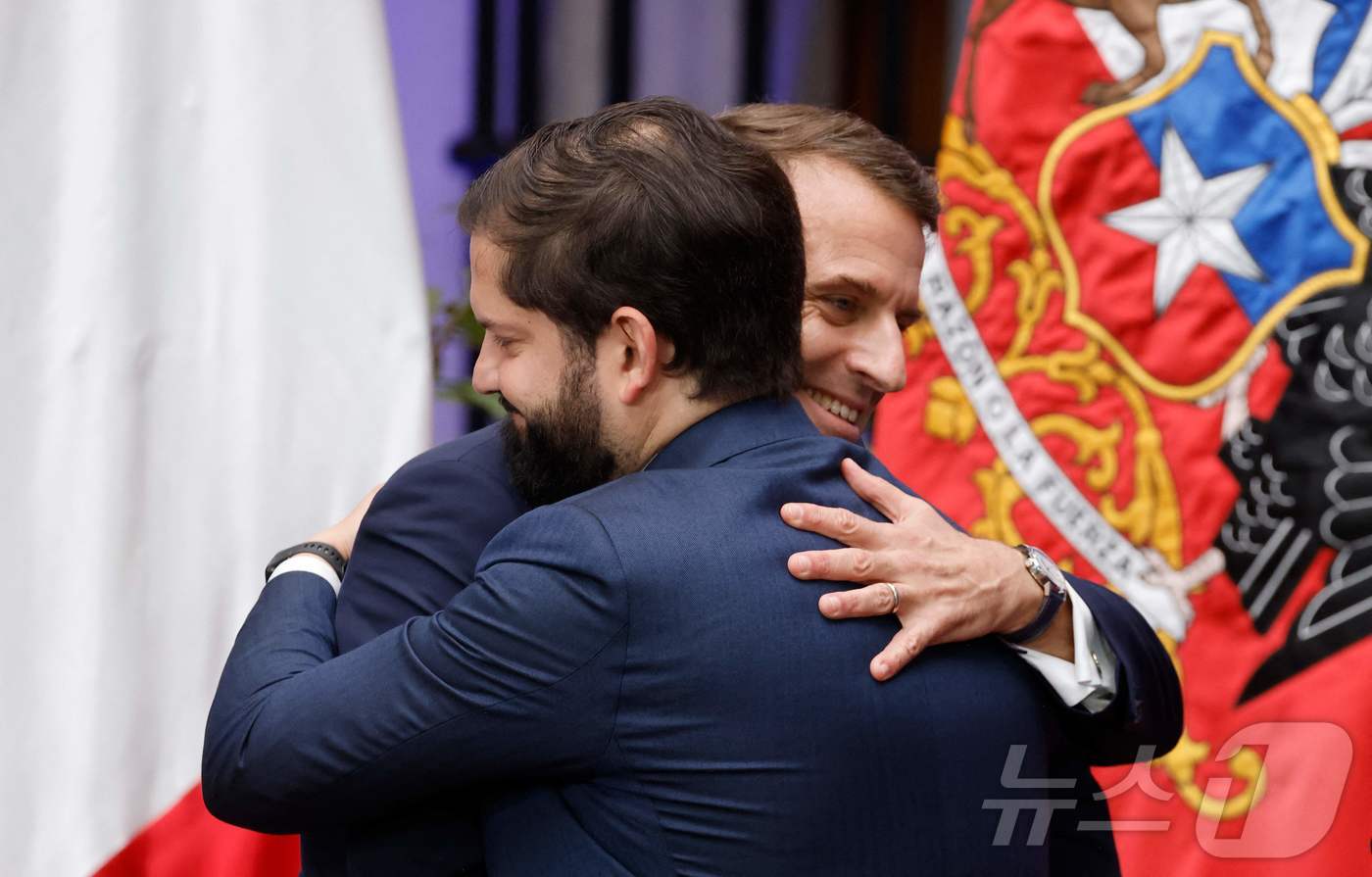 (산티아고 AFP=뉴스1) 우동명 기자 = 에마뉘엘 마크롱 프랑스 대통령이 20일(현지시간) 산티아고 대통령 궁에서 가브리엘 보리치 칠레 대통령과 공동 성명을 발표한 뒤 포옹을 하 …