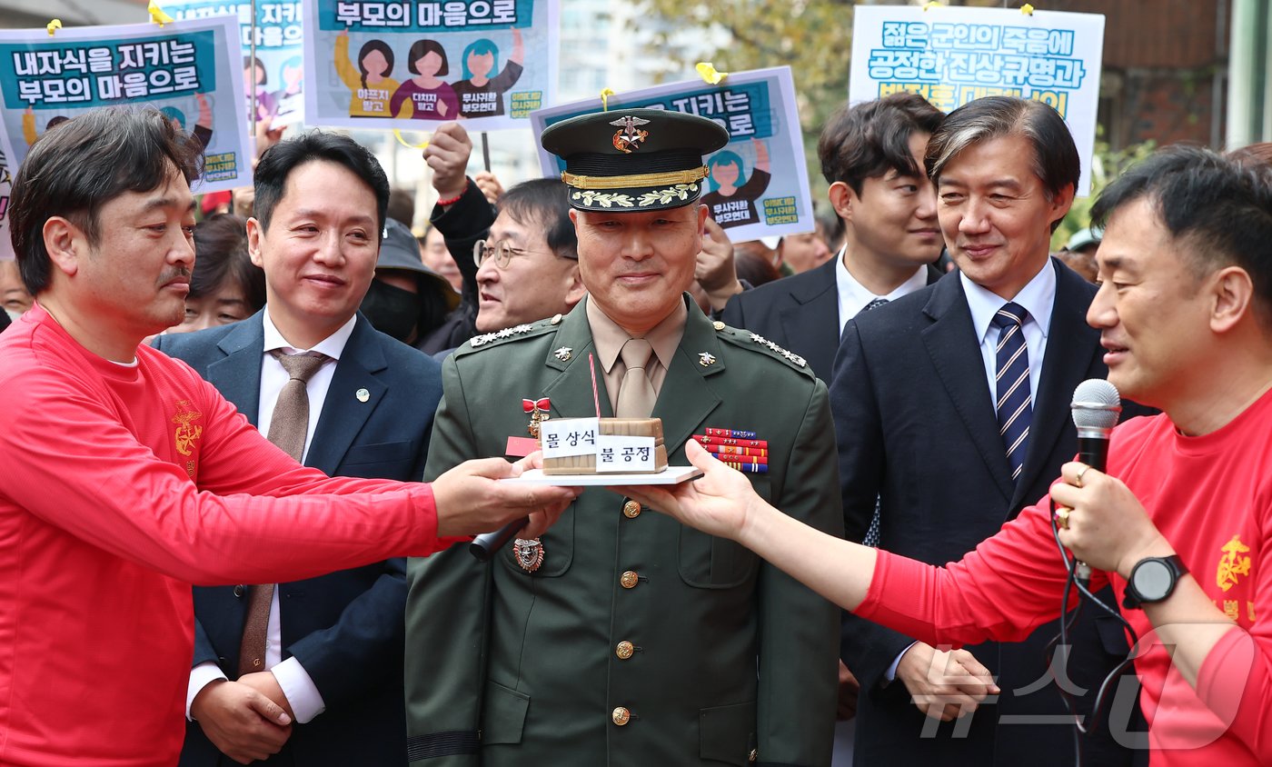 본문 이미지 - 채 해병 순직사건 수사 이첩 관련 항명 및 상관명예훼손 혐의로 기소된 박정훈 전 해병대 수사단장(대령)이 21일 서울 용산구 중앙지역군사법원에서 열린 10차 공판에 앞서 가진 기자회견에서 해병대 동기로 부터 생일 축하 선물을 받고 있다. 2024.11.21/뉴스1 ⓒ News1 김도우 기자
