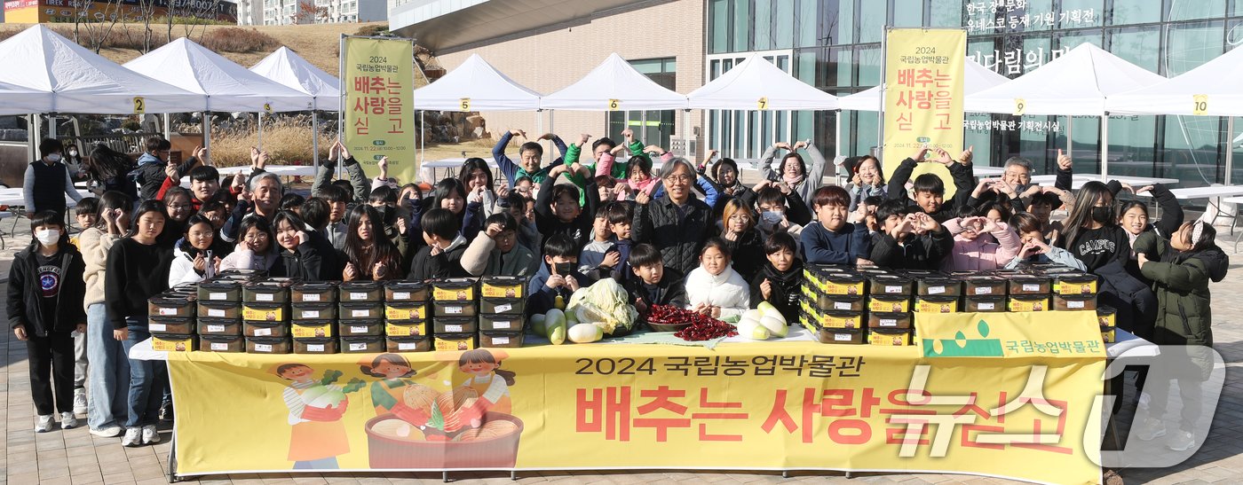 김치의 날인 22일 경기 수원시 권선구 국립농업박물관에서 열린 ‘배추는 사랑을 싣고!’ 김장 체험 프로그램에서 구운초등학교 학생들이 직접 심고 수확한 무와 배추로 김장 체험을 마치고 기념촬영을 하고 있다. 이날 학생들이 담근 김장 김치 100통과 깍두기 50통은 권선구청을 통해 지역사회에 기부할 예정이다. 2024.11.22/뉴스1 ⓒ News1 김영운 기자