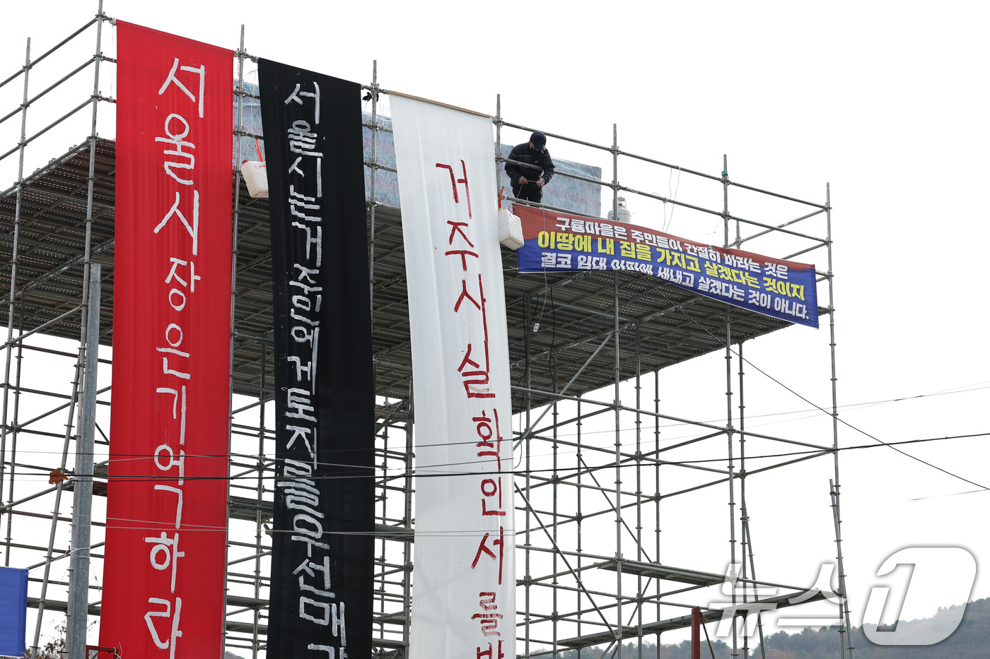 (서울=뉴스1) 신웅수 기자 = 25일 서울 강남구 구룡마을 입구에서 주민들이 설치한 망루 앞에서 거주사실확인서 발급을 촉구하는 농성을 하고 있다.구룡마을 주민들은 강남구청이 거주 …