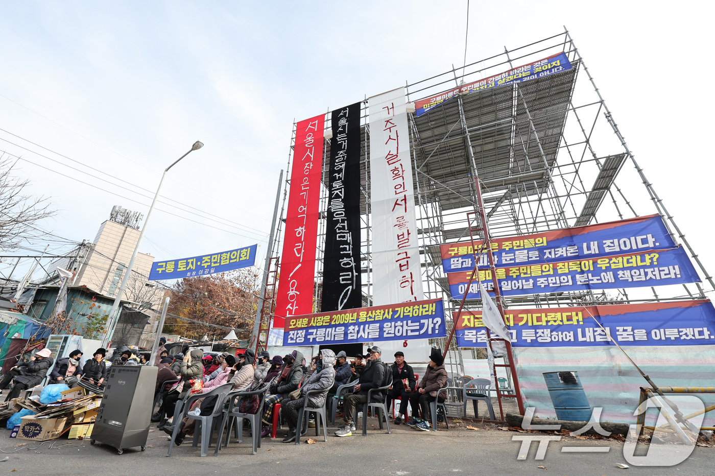 (서울=뉴스1) 신웅수 기자 = 25일 서울 강남구 구룡마을 입구에서 주민들이 설치한 망루 앞에서 거주사실확인서 발급을 촉구하는 농성을 하고 있다.구룡마을 주민들은 강남구청이 거주 …