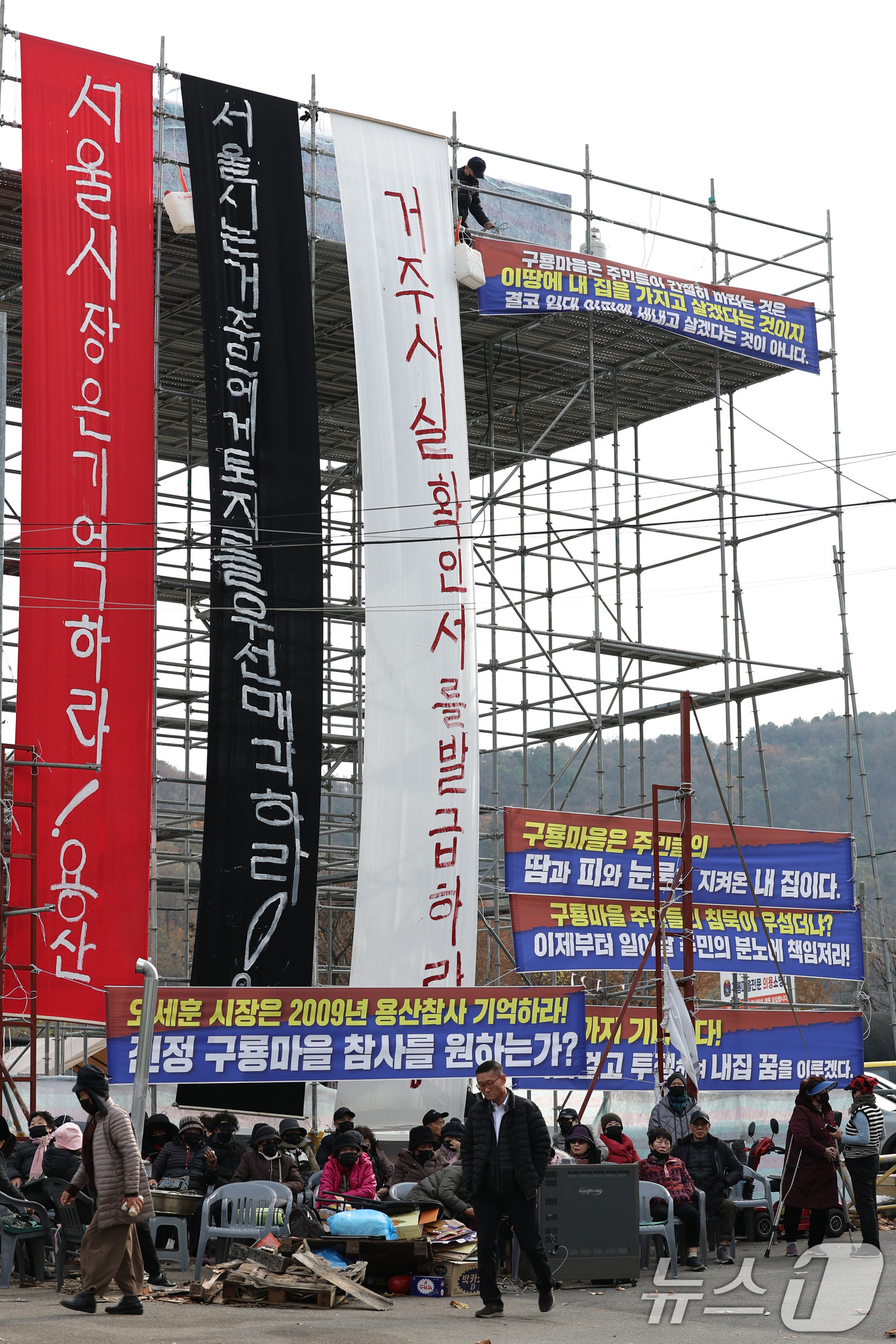 (서울=뉴스1) 신웅수 기자 = 25일 서울 강남구 구룡마을 입구에서 주민들이 설치한 망루 앞에서 거주사실확인서 발급을 촉구하는 농성을 하고 있다.구룡마을 주민들은 강남구청이 거주 …